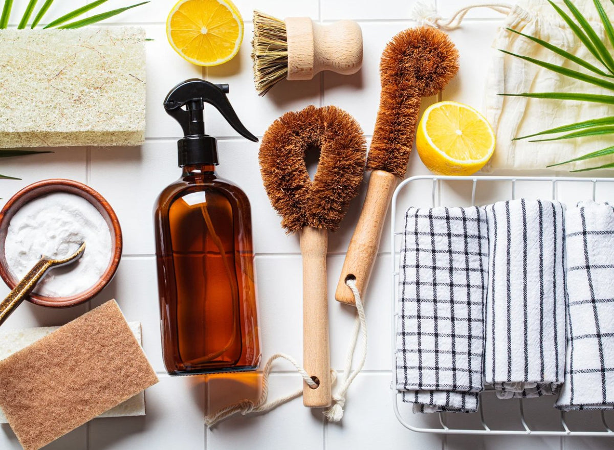 Eco-friendly laundry detergent bottles with lemons, eucalyptus, and natural cleaning ingredients on a white background.