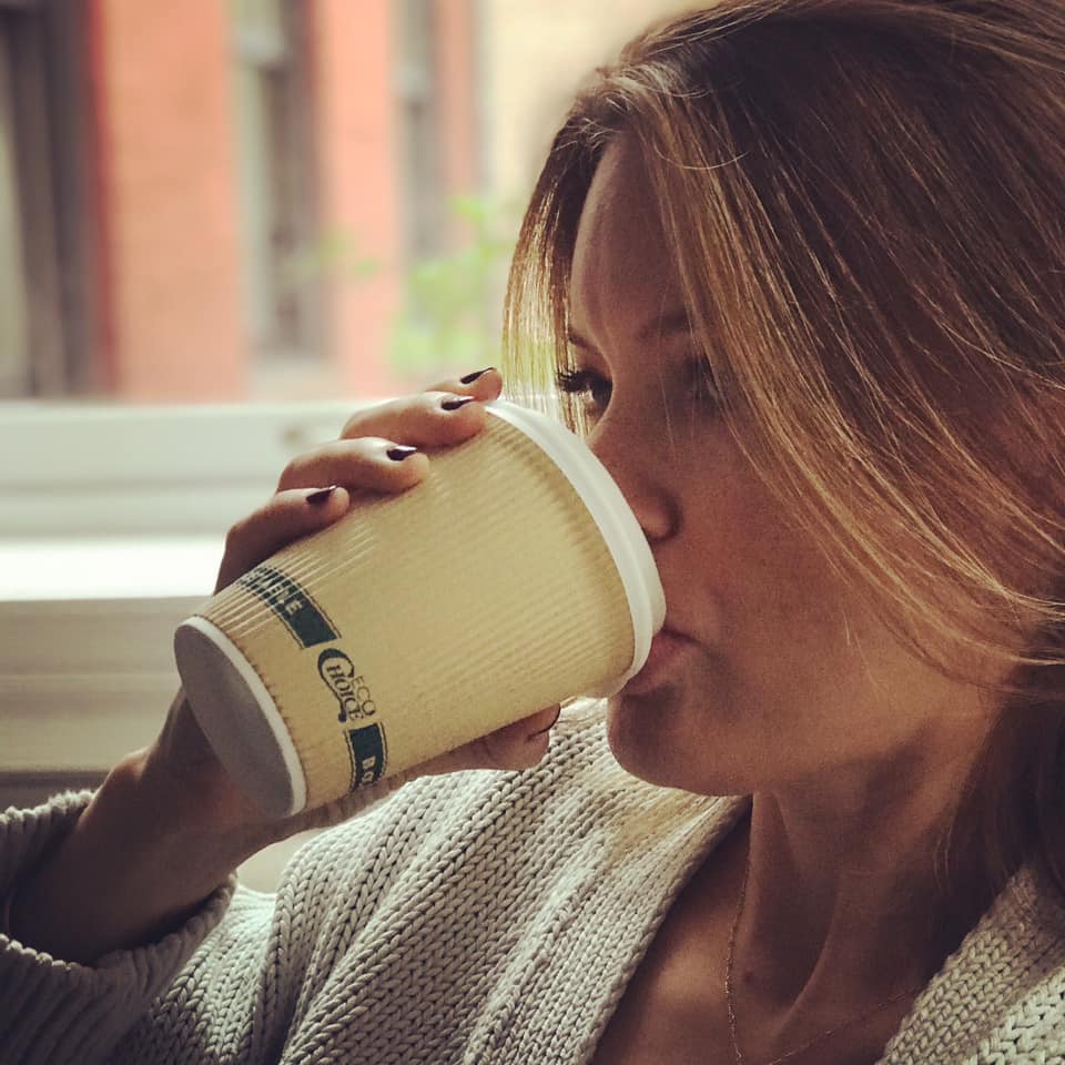 Our founder Maia drinking to-go coffee cup latte.