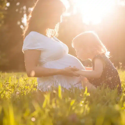 Pregnant woman with child at sunset