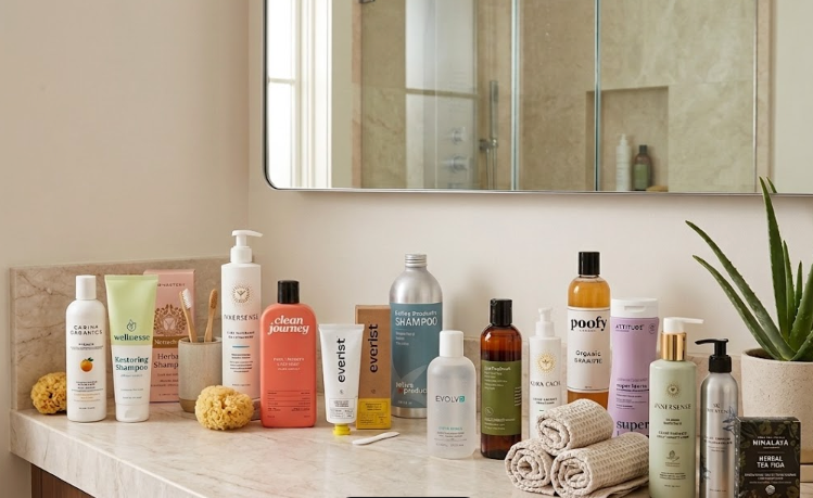 Gemini said A selection of hair and body care products including shampoos, conditioners, a bar of soap, and accessories like a toothbrush and towels, are arranged on a light-colored marble countertop in front of a mirror and a glass shower door.