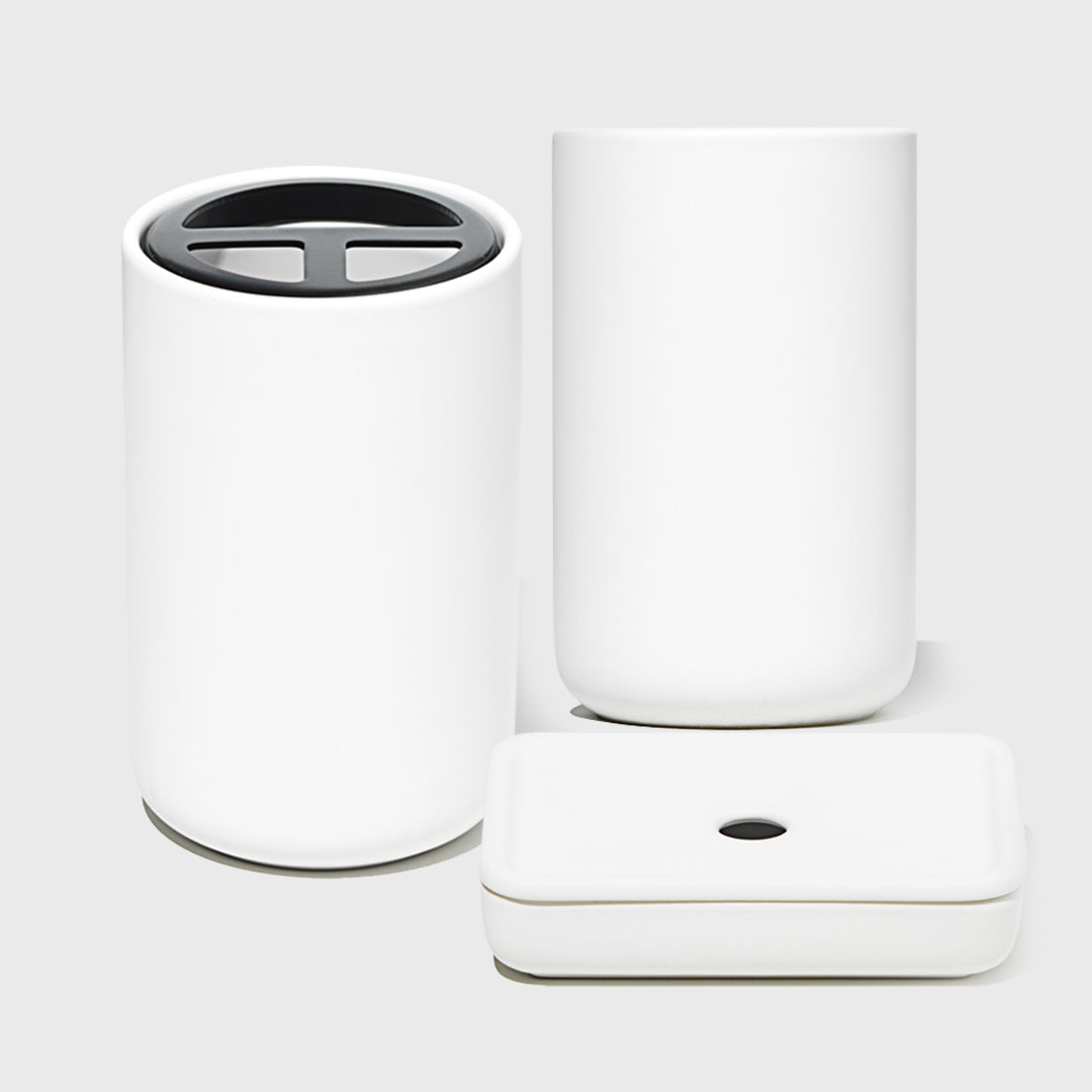 Set of white cylindrical containers with different designs on a light gray background