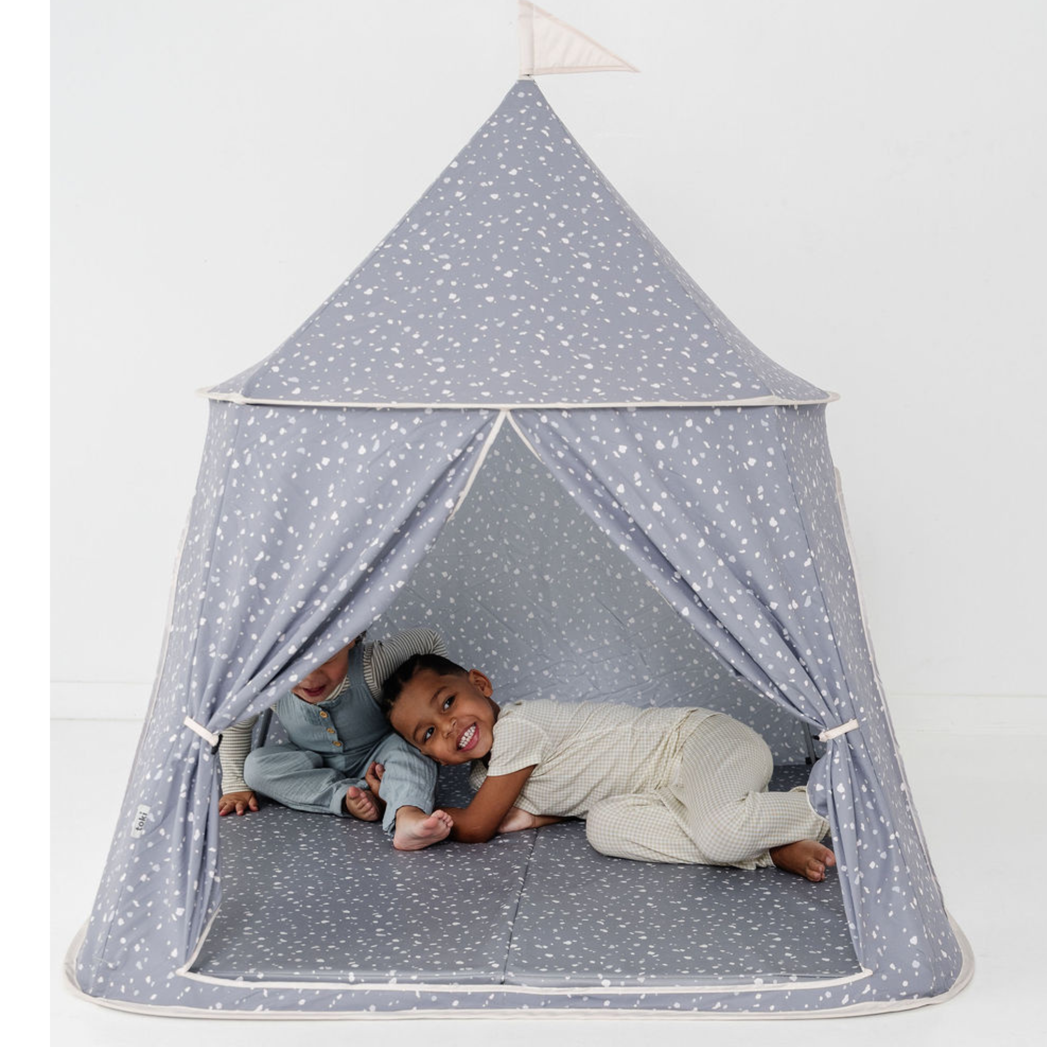 Children playing inside a star-patterned tent on a white background