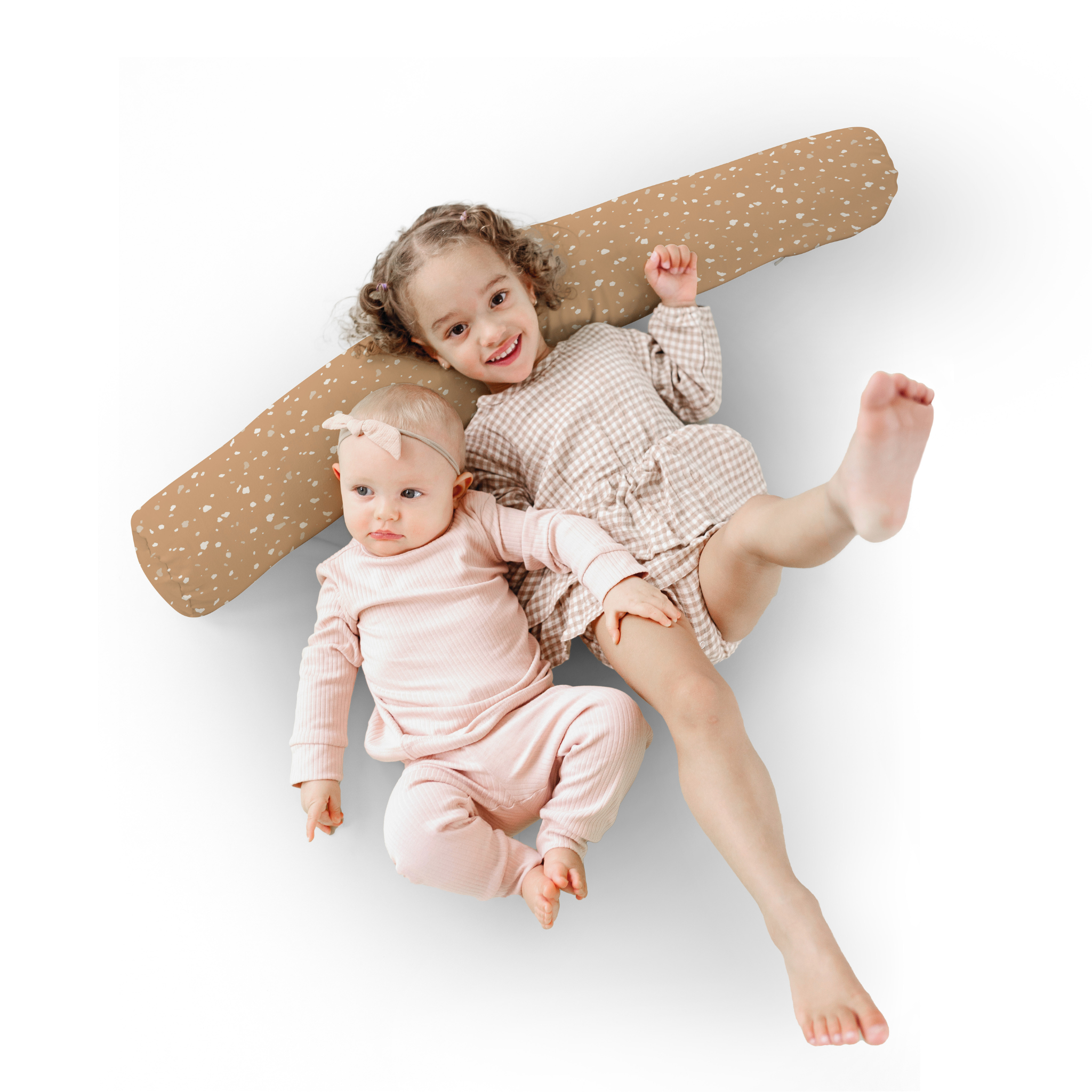 Two children lying on a wooden surfboard against a white background