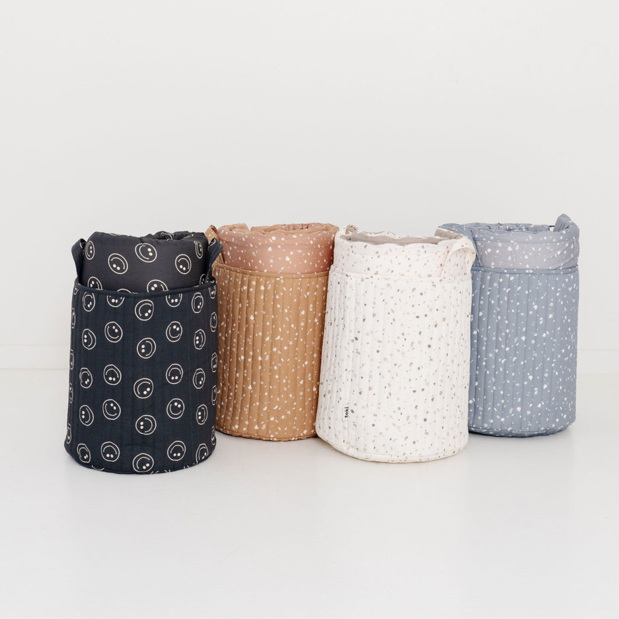 Four fabric storage bins with different patterns on a white background