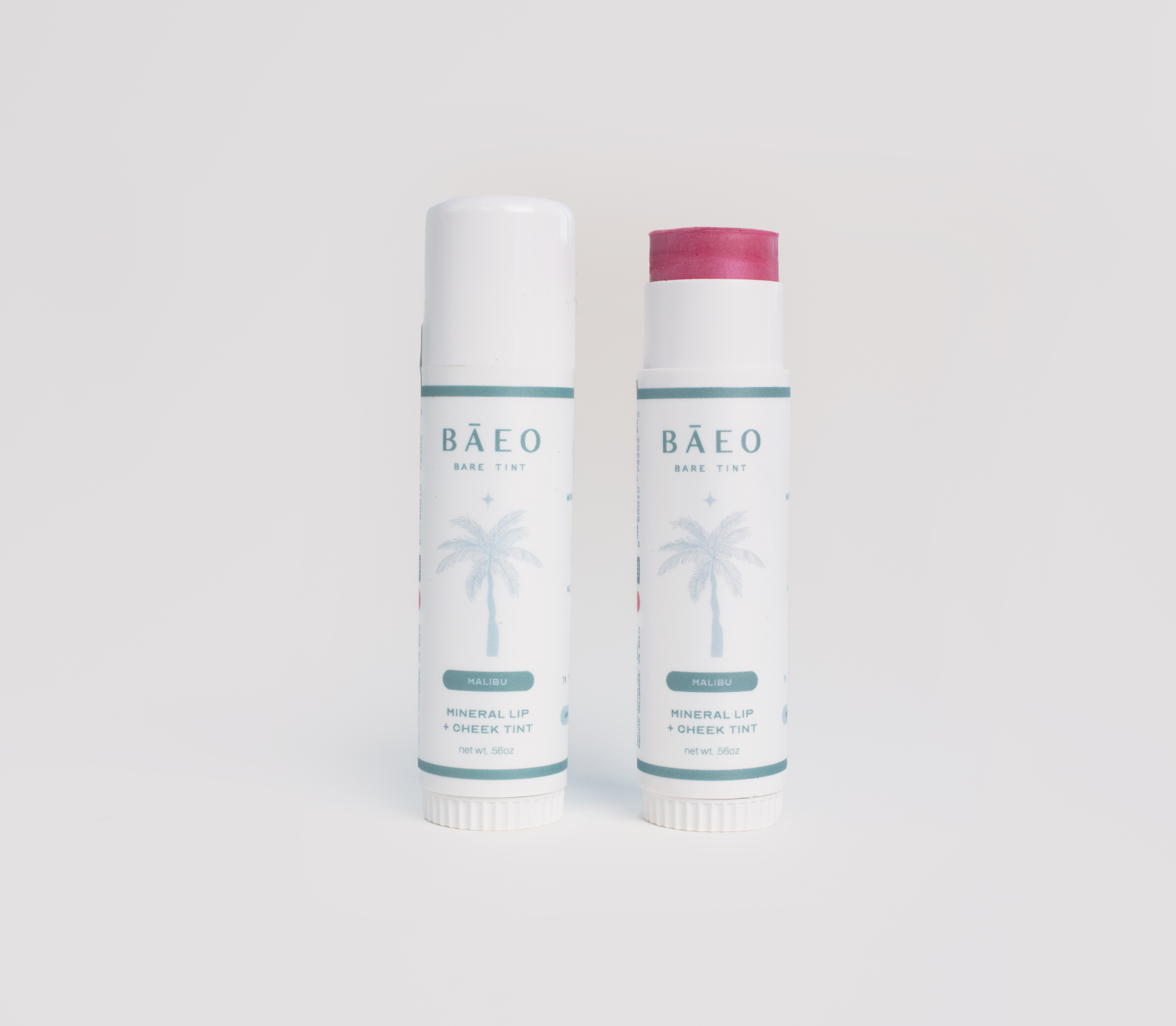 Two Bäeo lip balm tubes on a light gray background