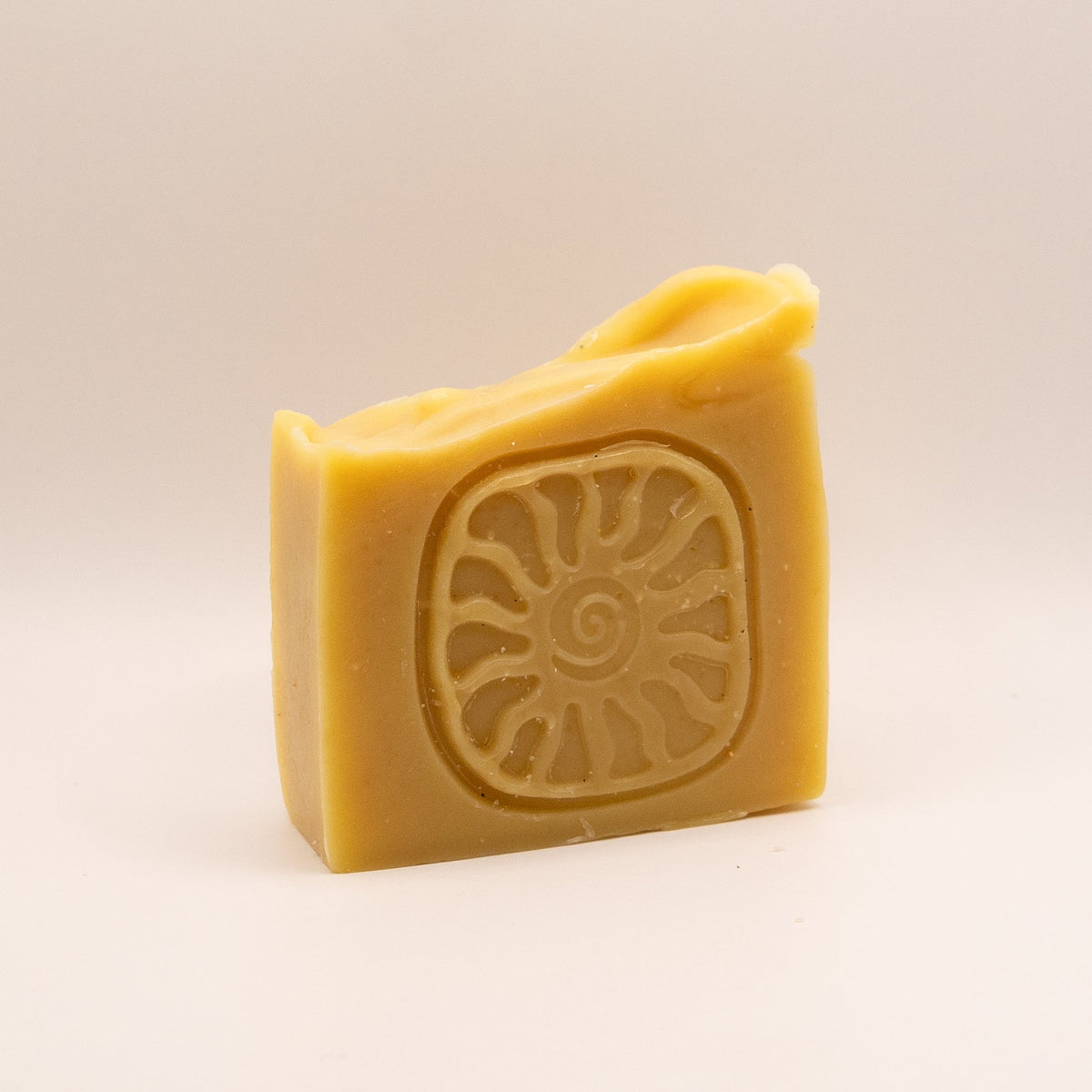 Bar of soap with a sun design on a beige background