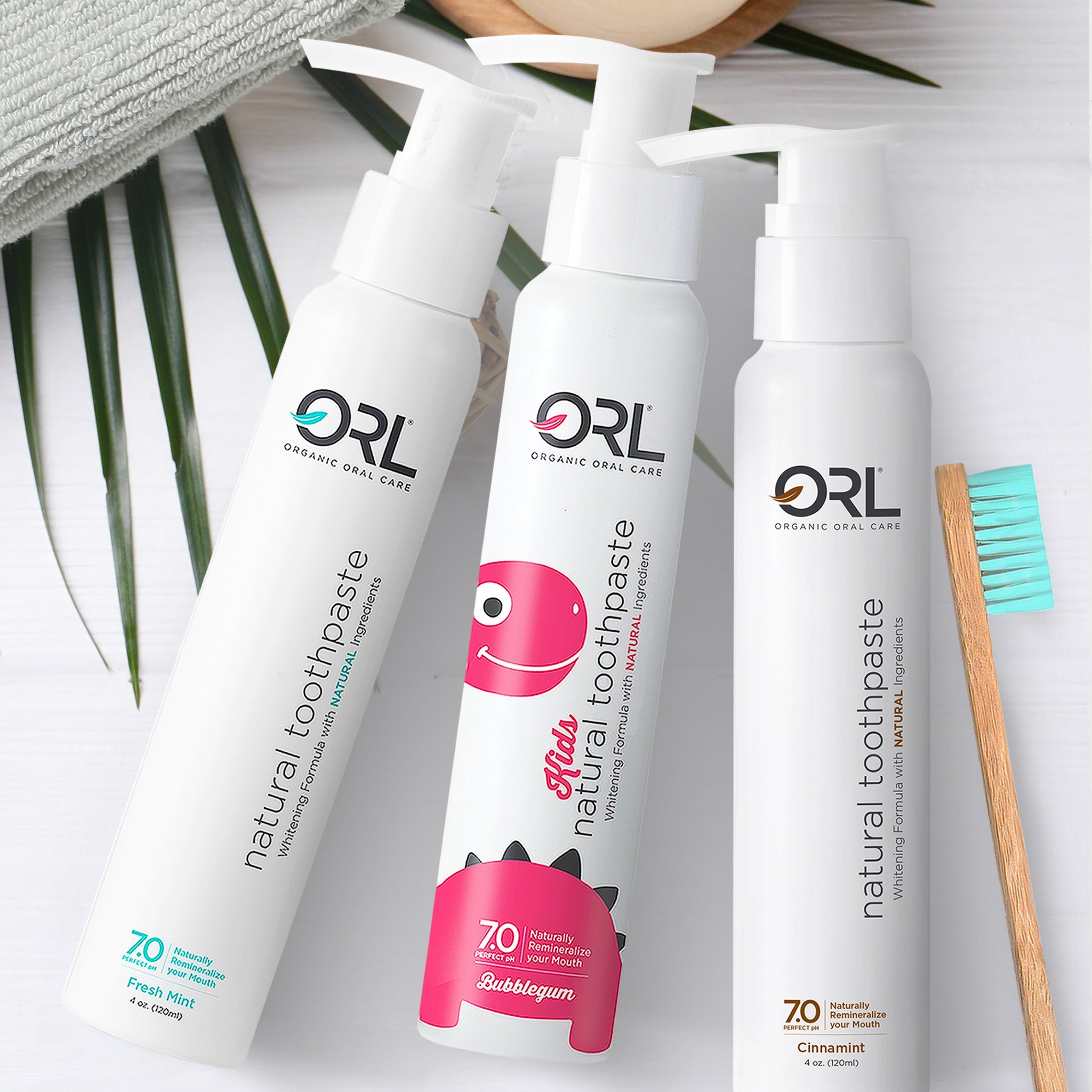 Three ORL toothpaste bottles with a toothbrush on a light background