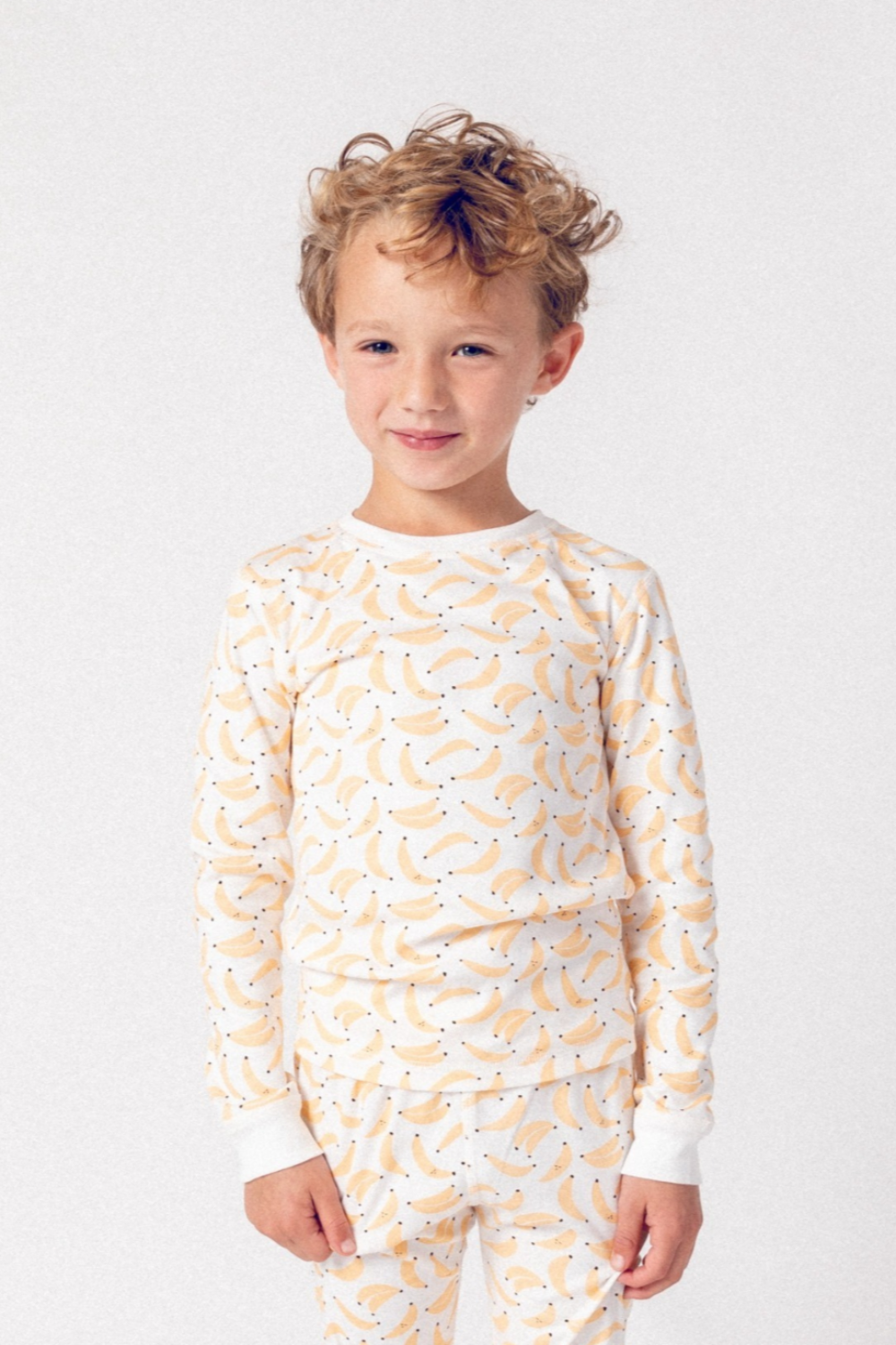 Child wearing a patterned pajama set on a plain background