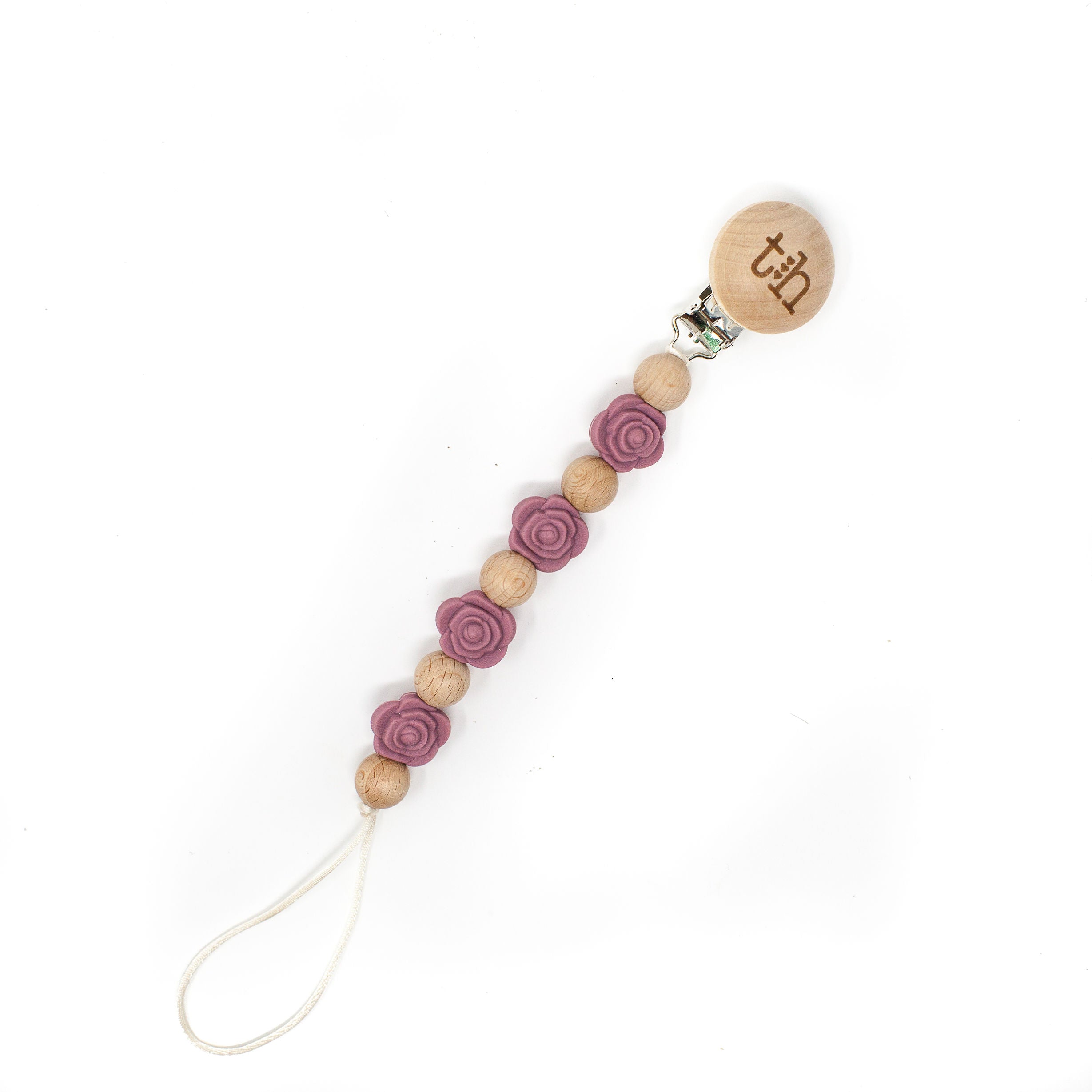 Wooden pacifier clip with purple floral beads on a white background