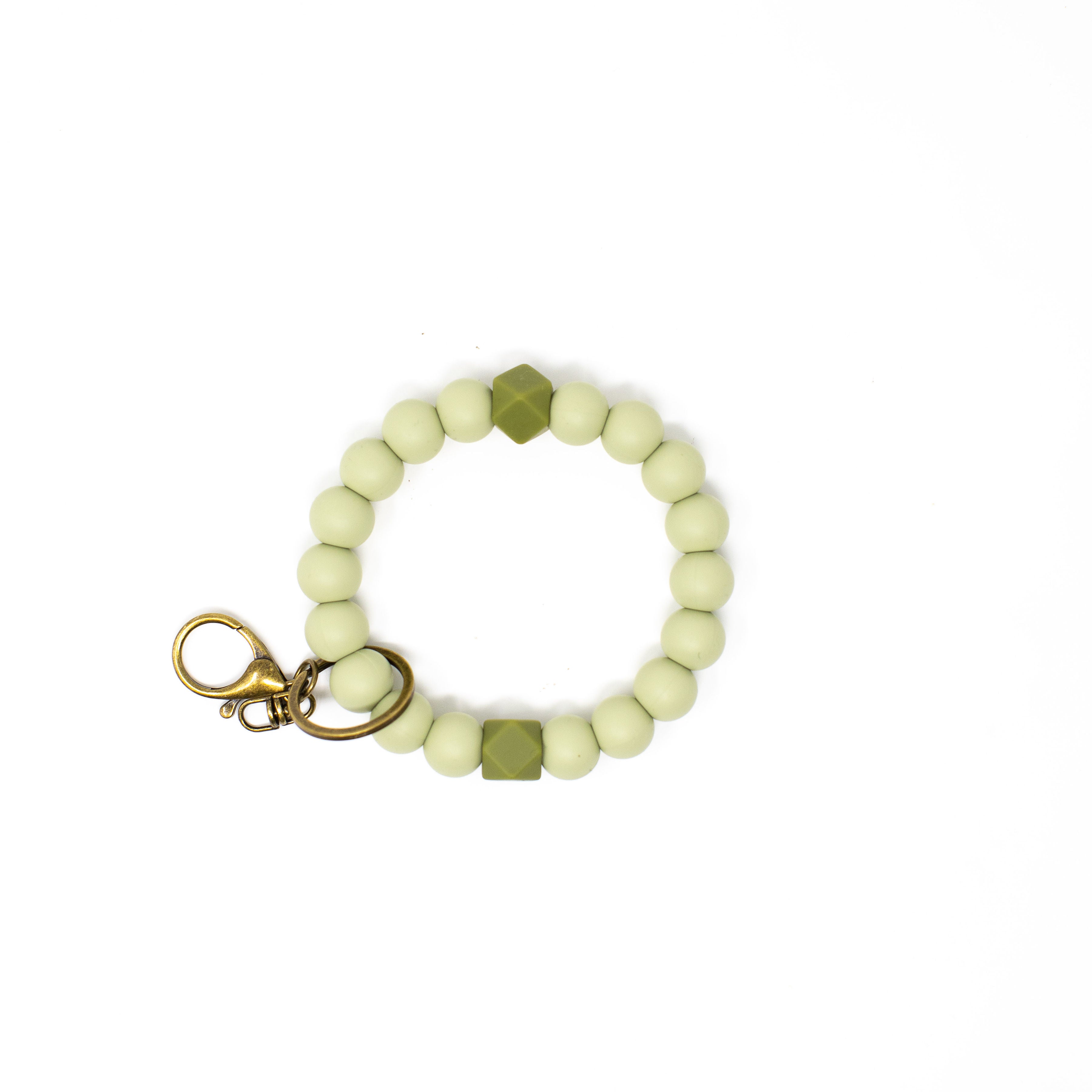 Bracelet with light green beads and gold accents on a white background