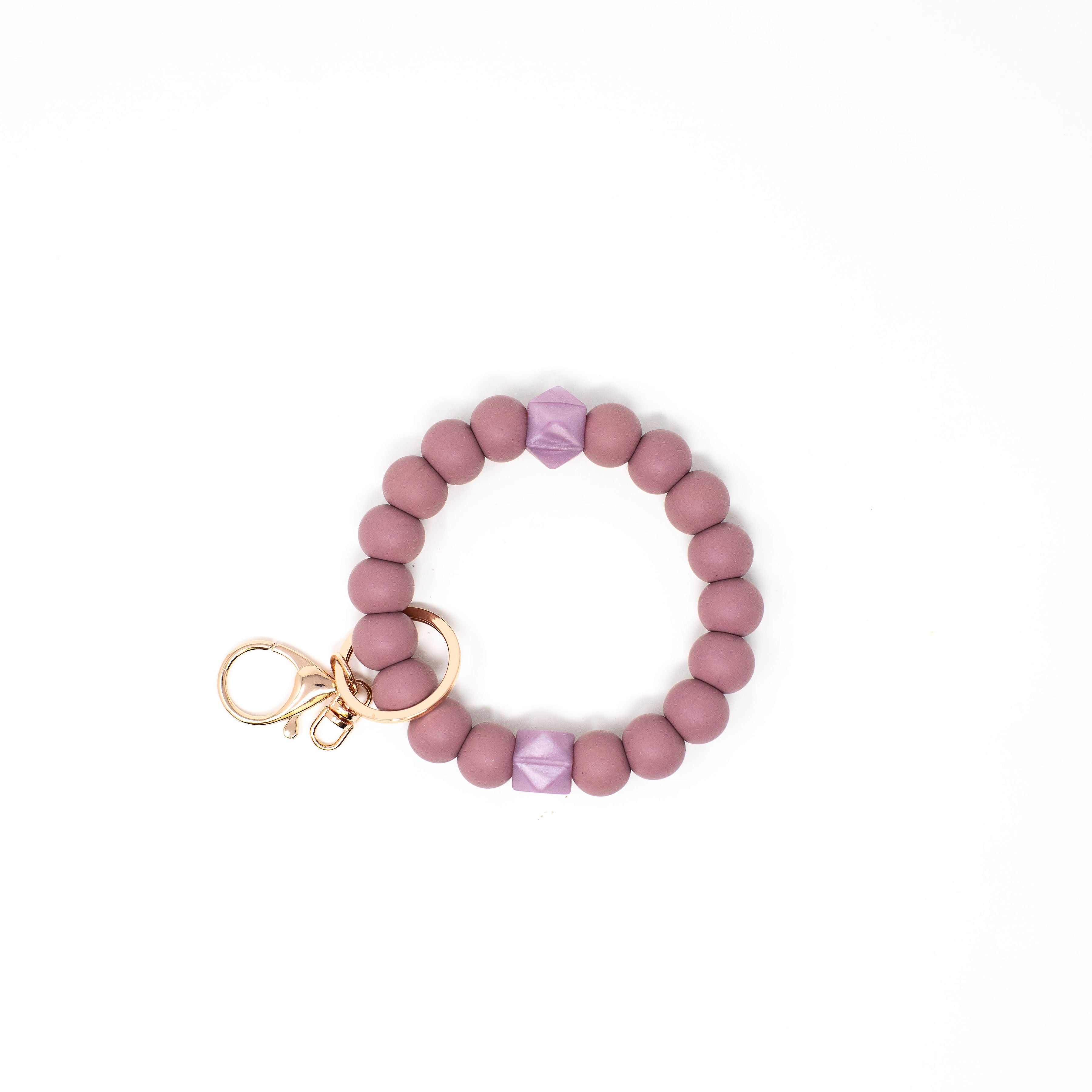 Pink beaded bracelet with a keychain on a white background