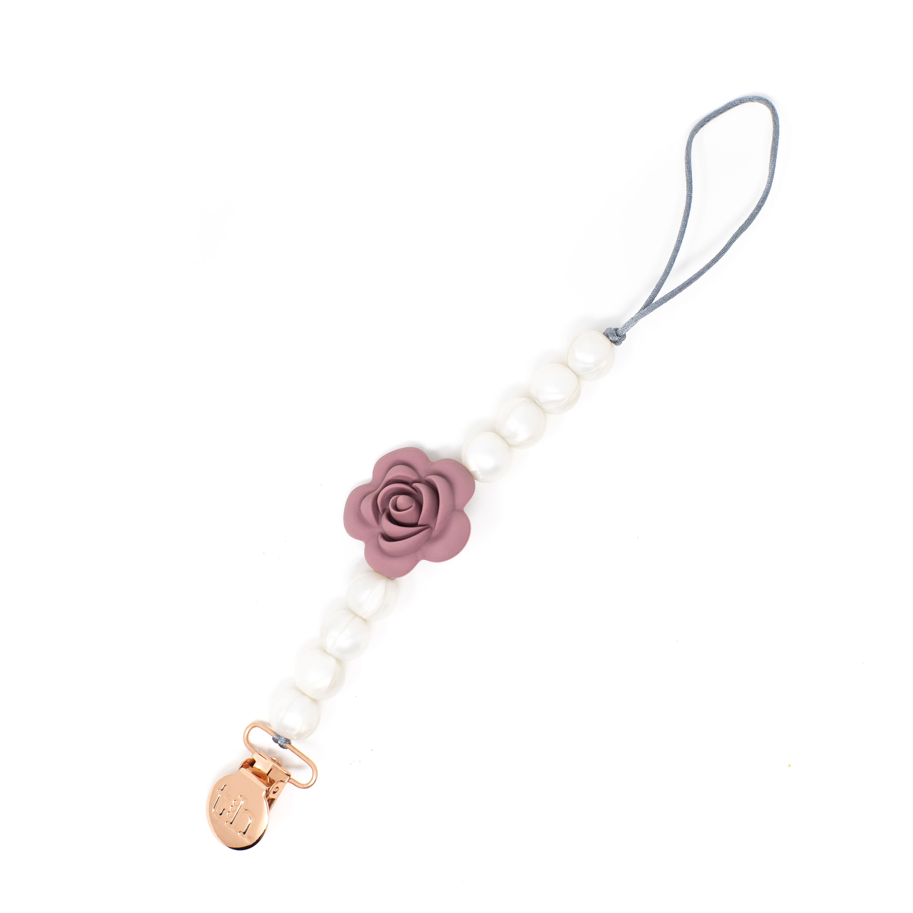 White beaded pacifier clip with a pink rose charm and gold accent on a white background