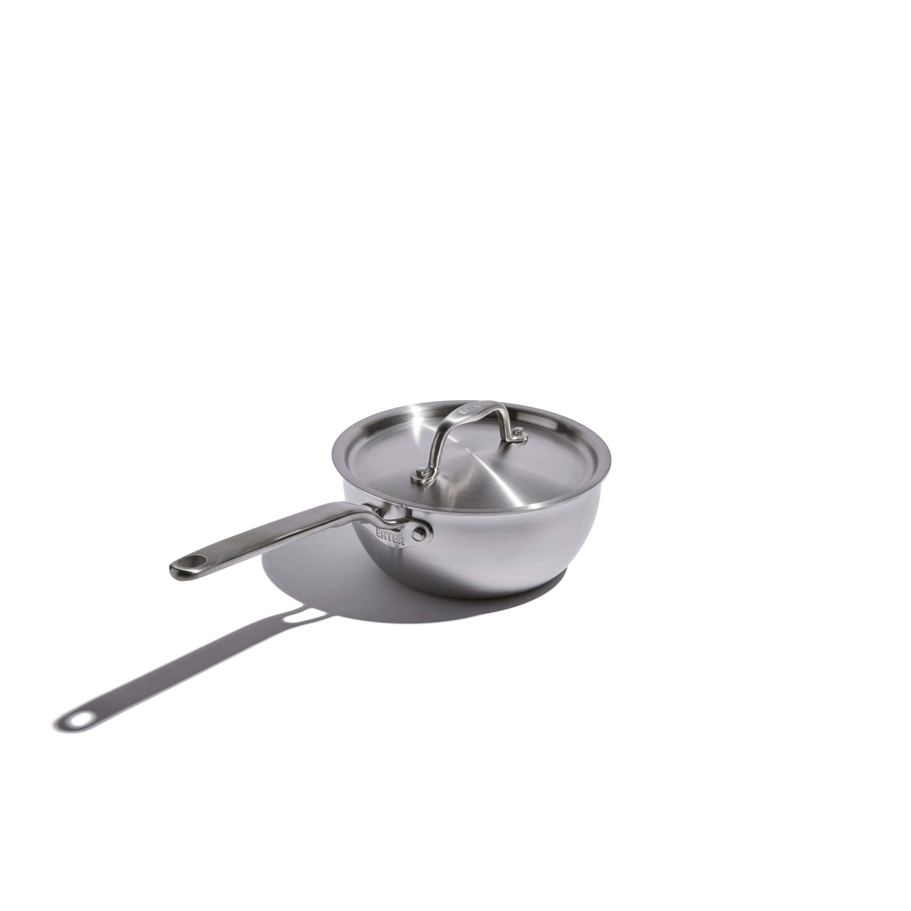 Stainless steel saucepan with lid on a white background