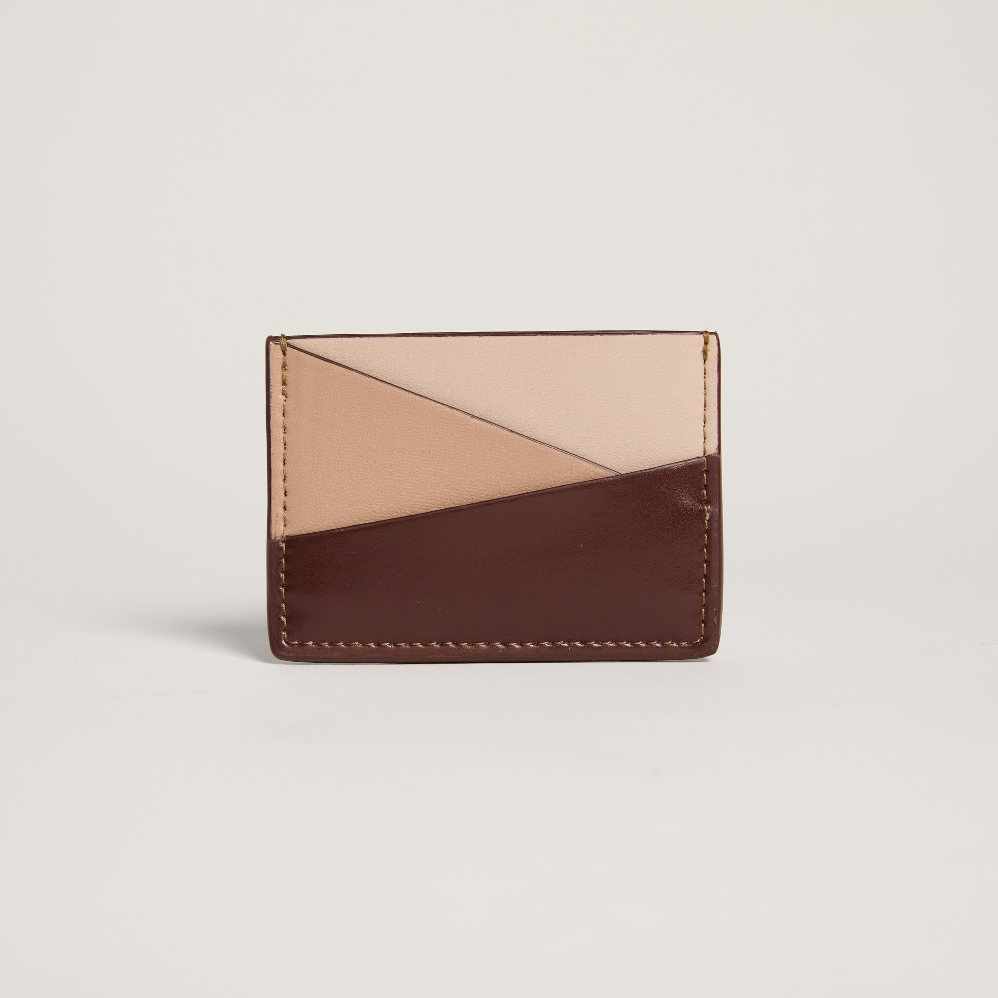 Two-tone brown and beige cardholder on a light gray background