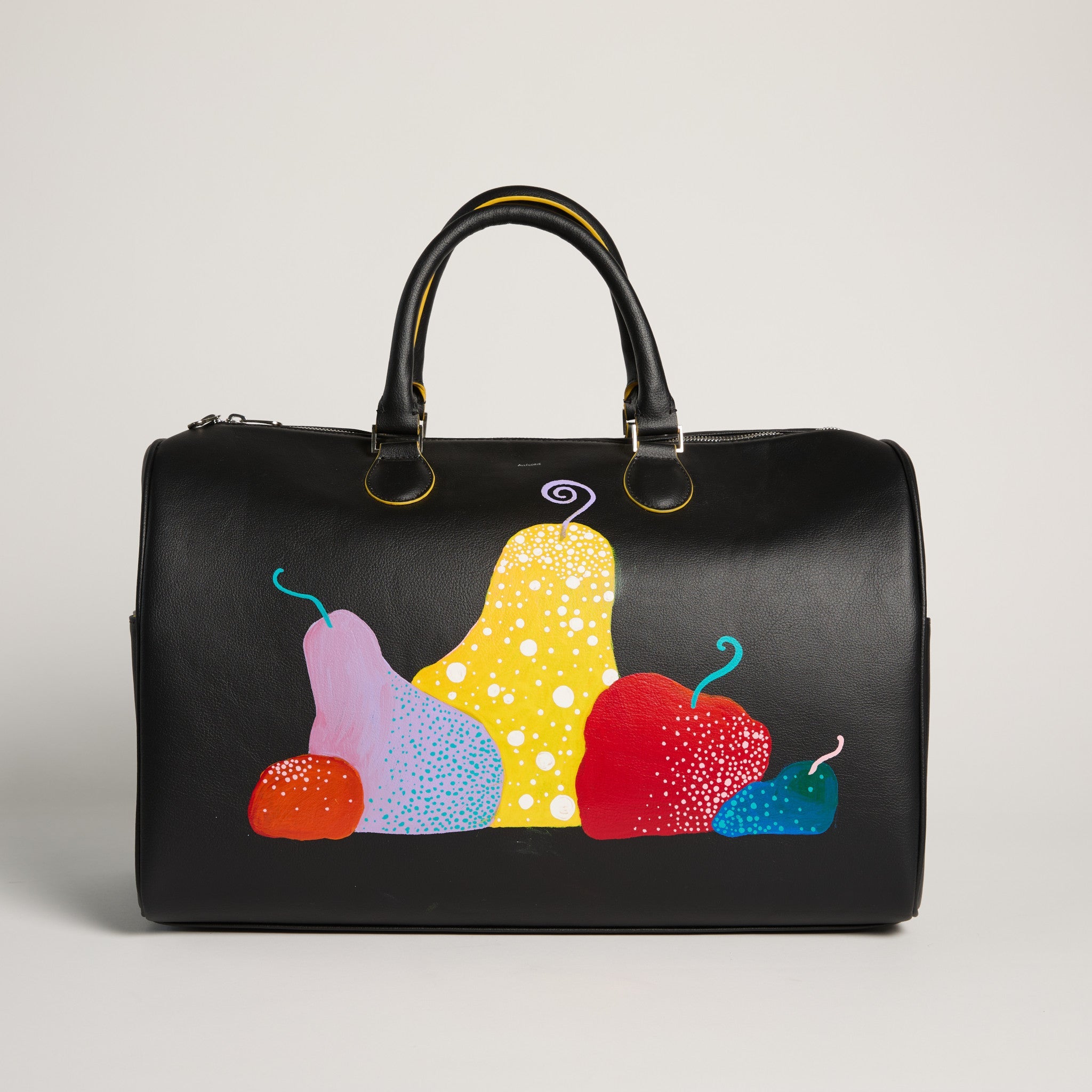 Black duffel bag with colorful fruit illustrations on a light gray background