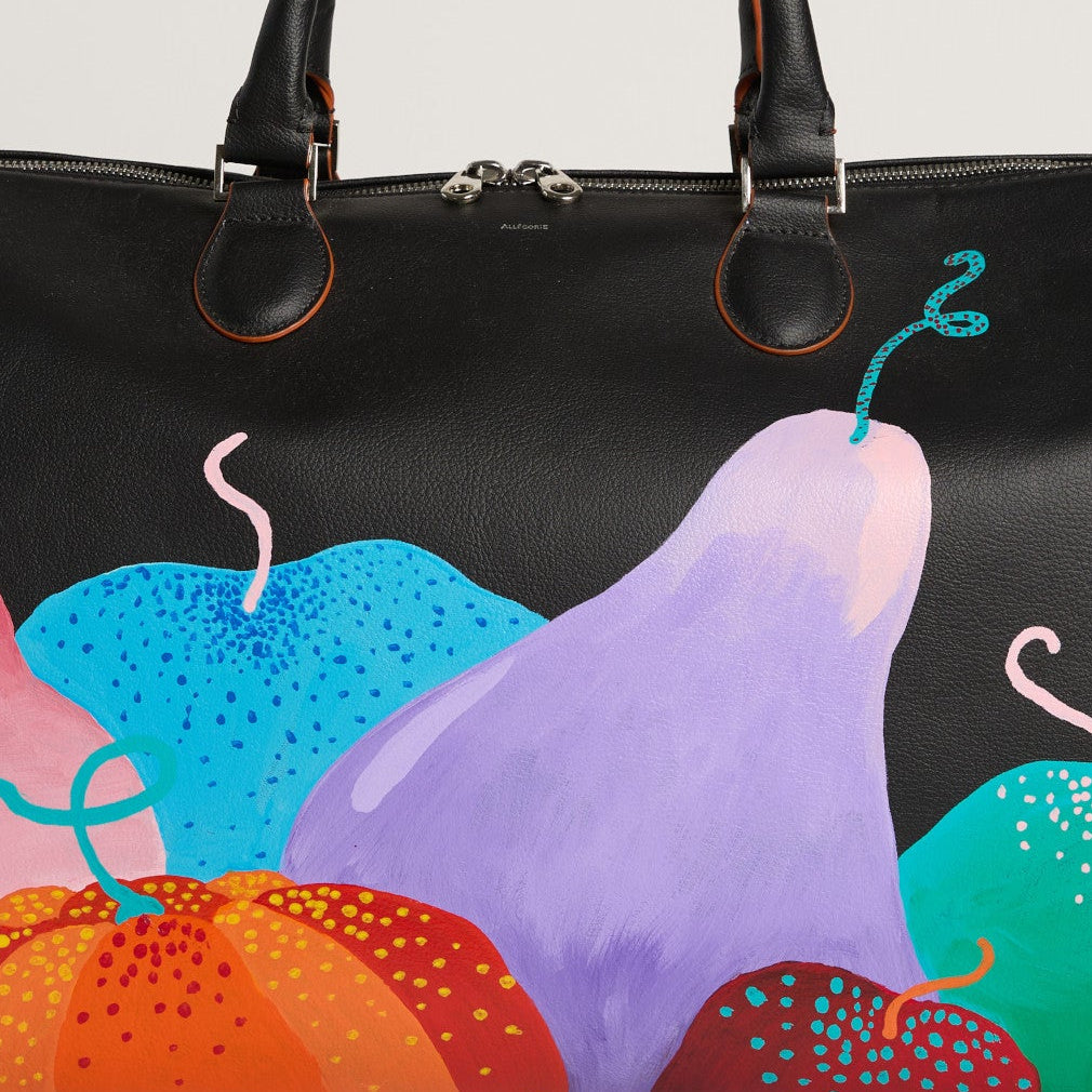 Black handbag with colorful abstract design on a light gray background