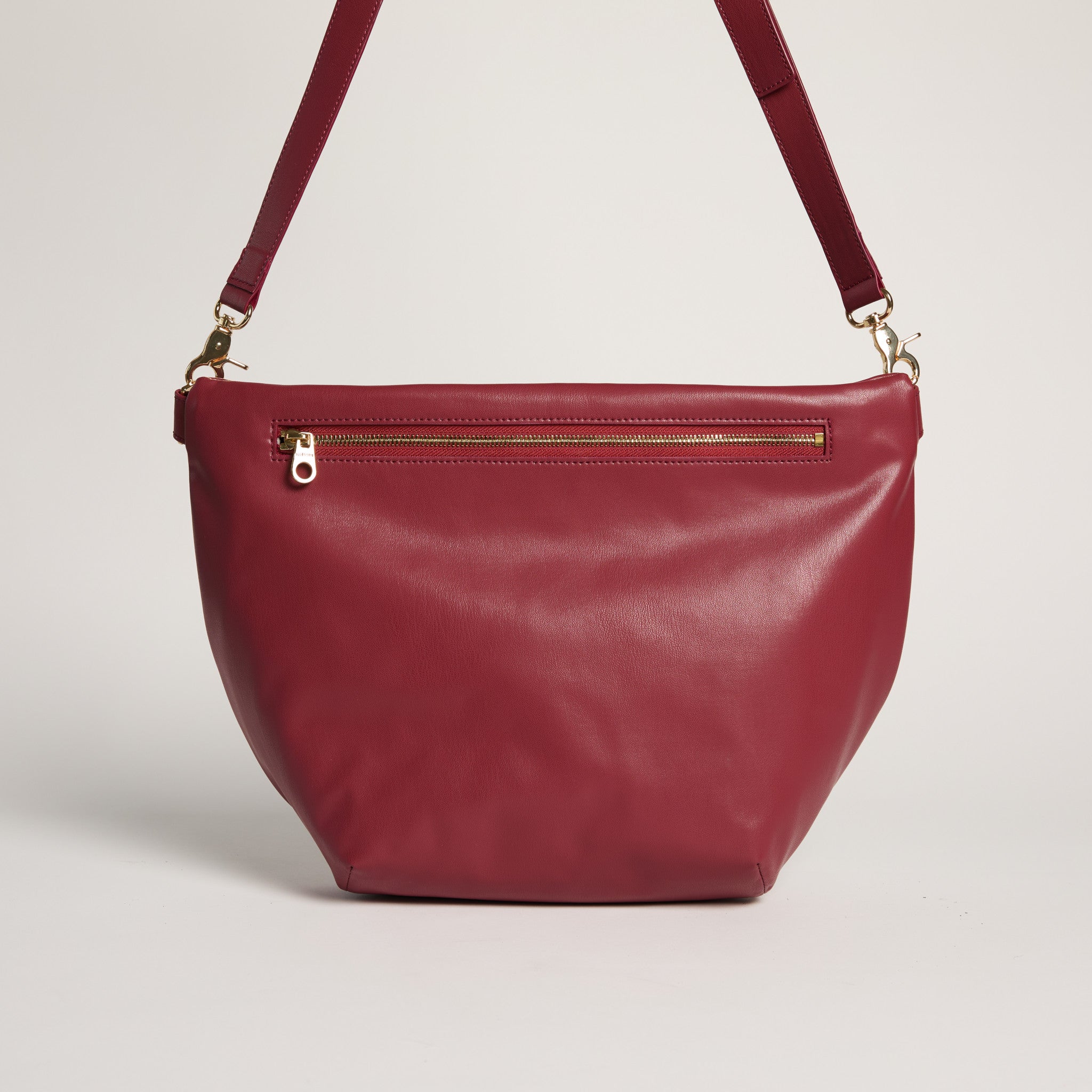 Red handbag with a gold zipper on a light gray background