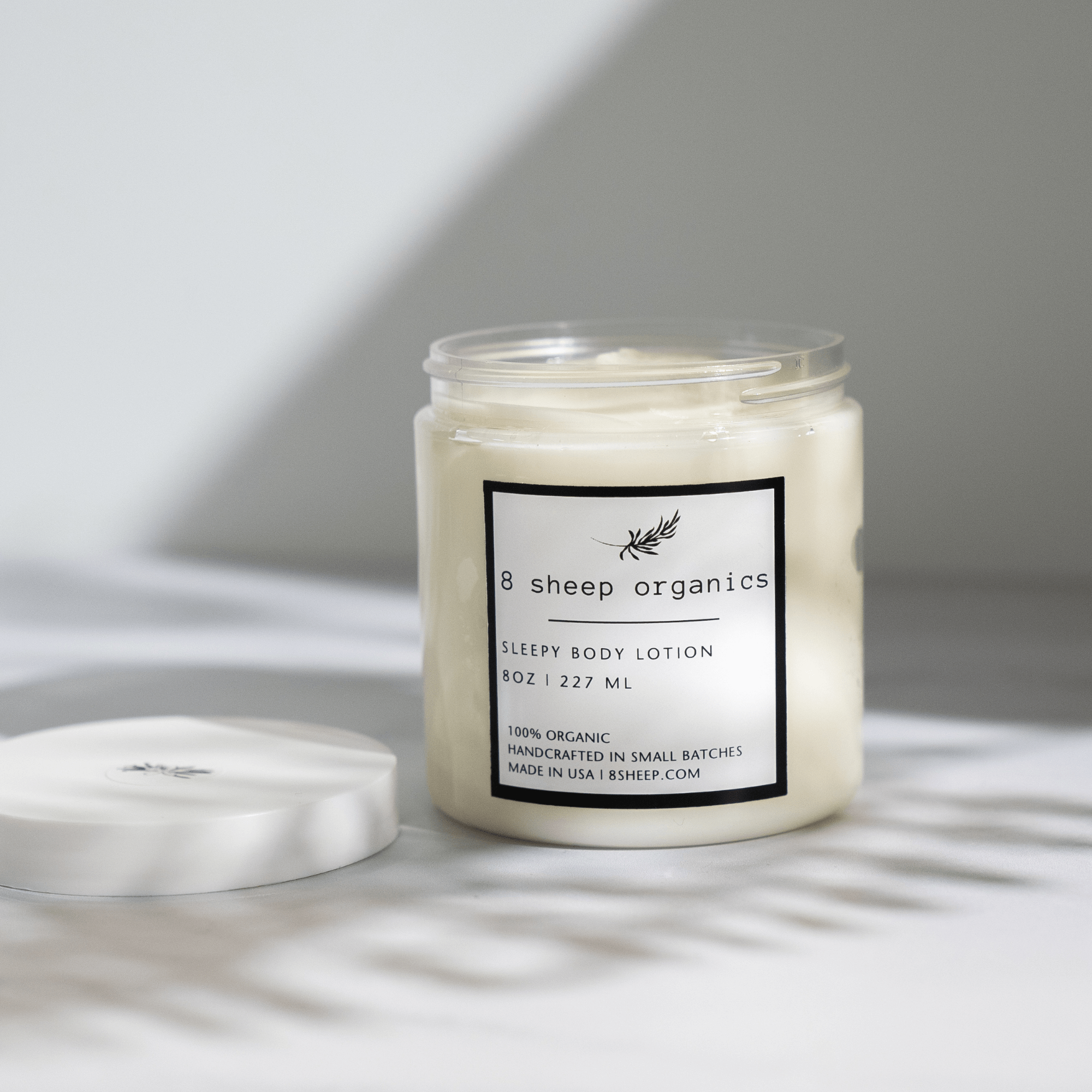 Jar of body lotion with a label on a light background