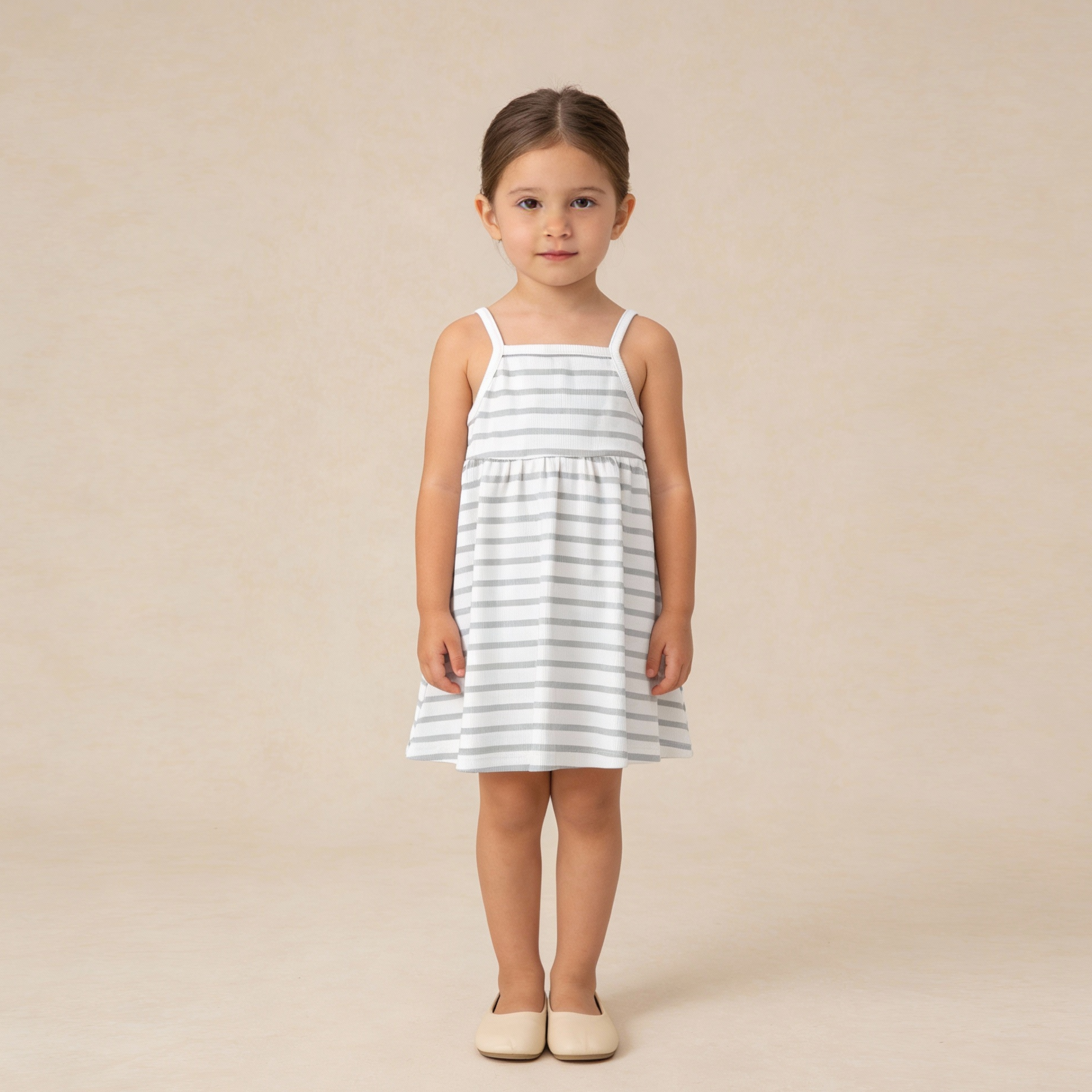 Young girl wearing a white and gray striped dress on a beige background
