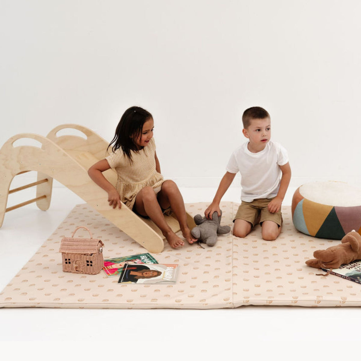 Cream-colored vegan leather play mat with soft rainbow accents