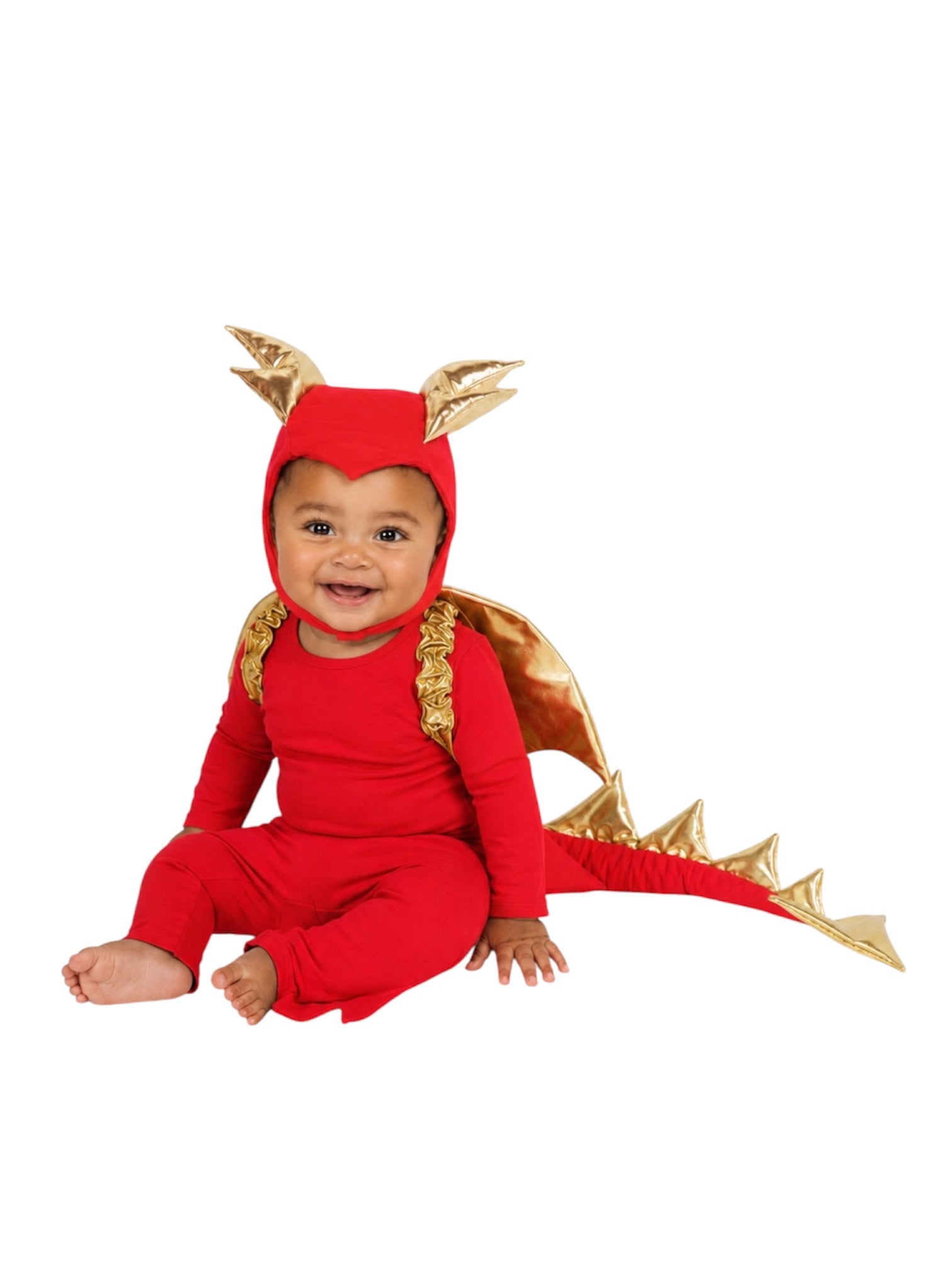 A baby wearing a red dragon costume with gold wings, gold spikes, and a gold horned hood, sitting against a plain white background.