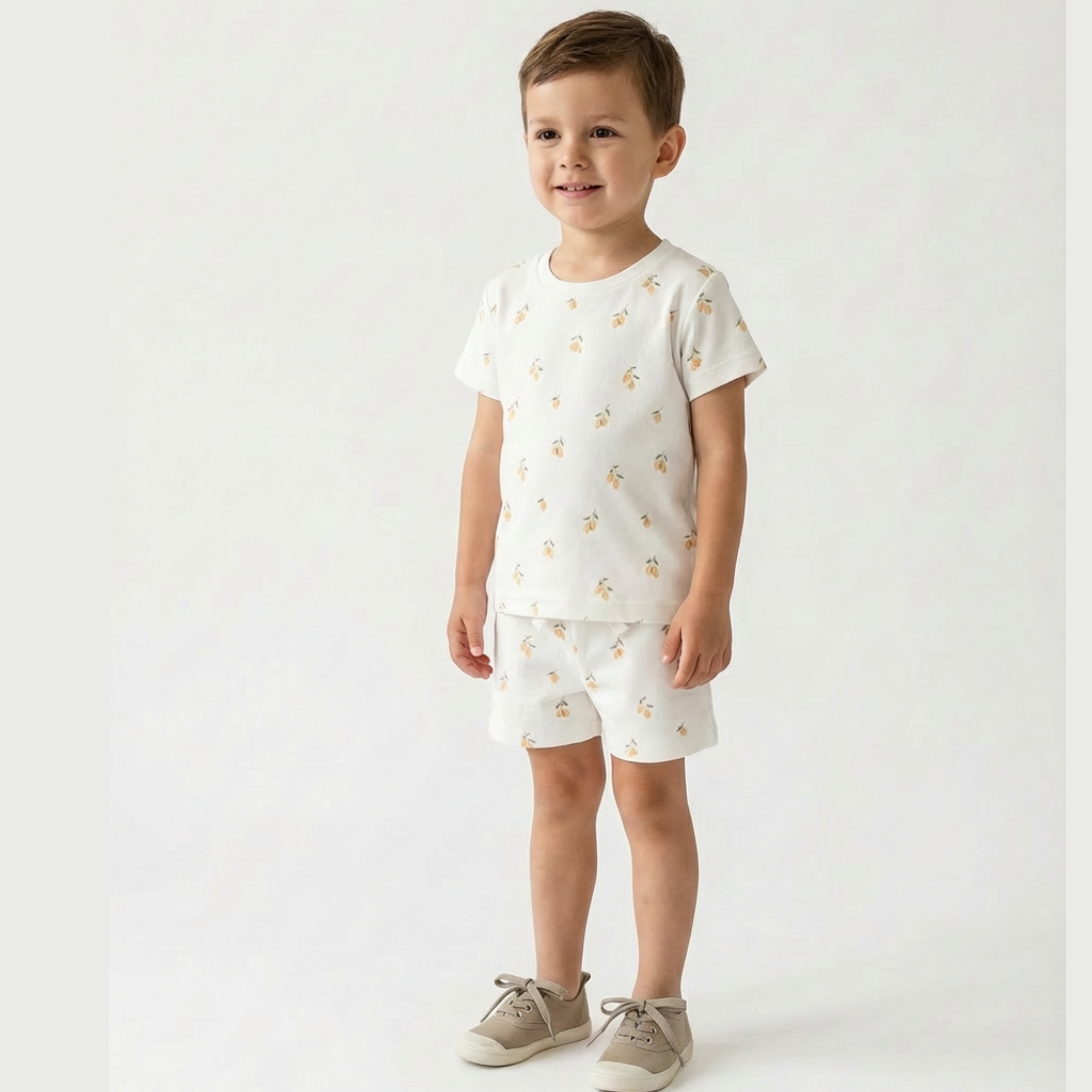 Child wearing a white outfit with small patterns on a plain background