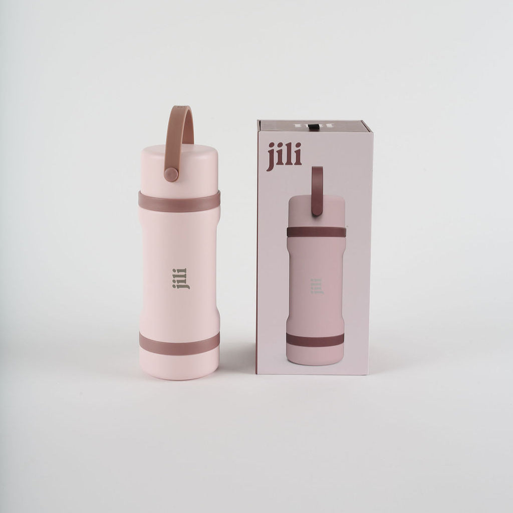 Pink insulated bottle with brown handle and matching packaging on a light gray background