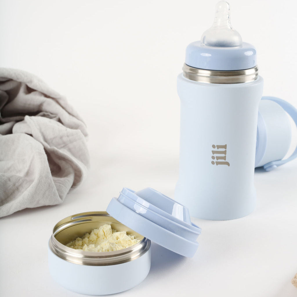 Light blue baby bottle with accessories on a white background