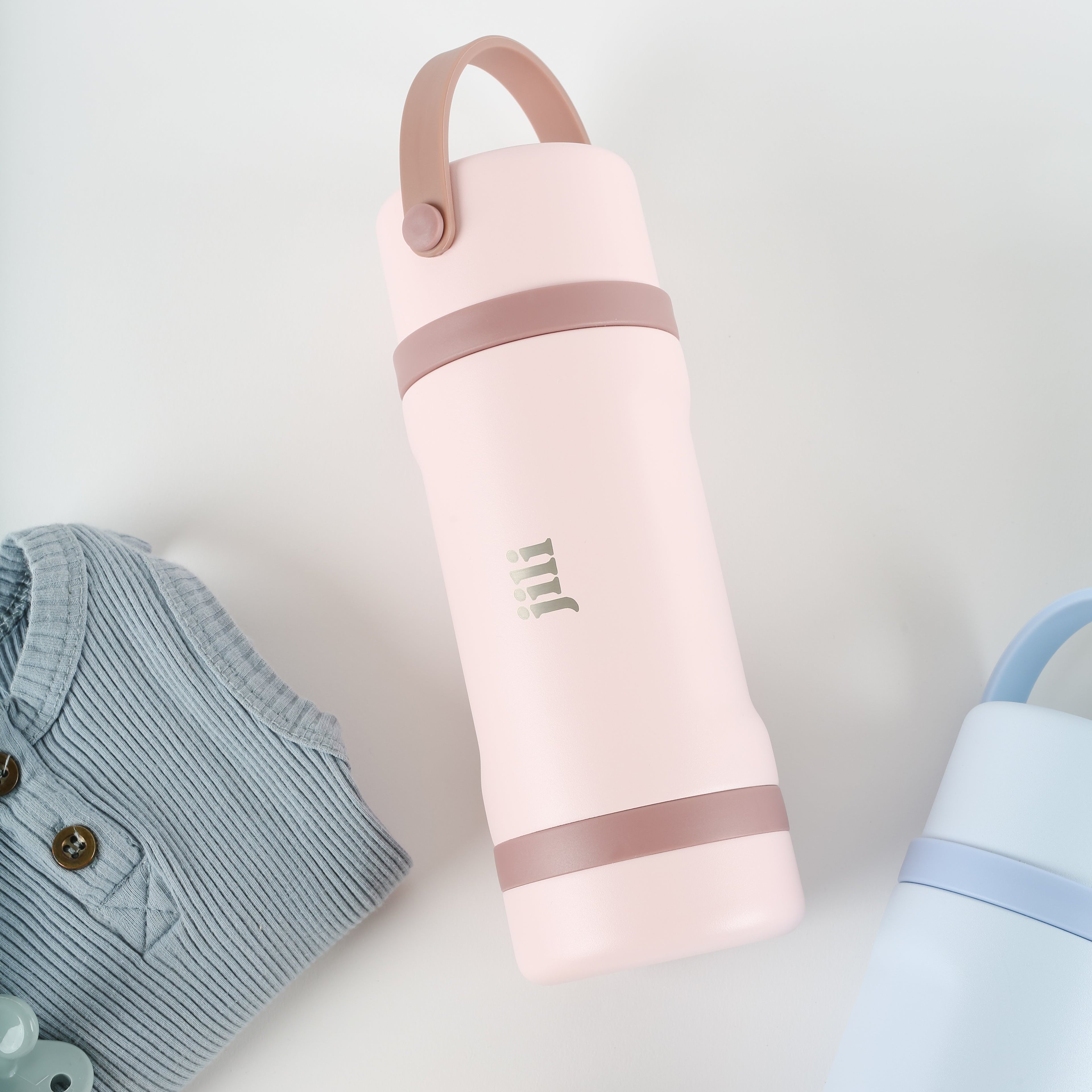 Pink water bottle with brown handle on a light gray background