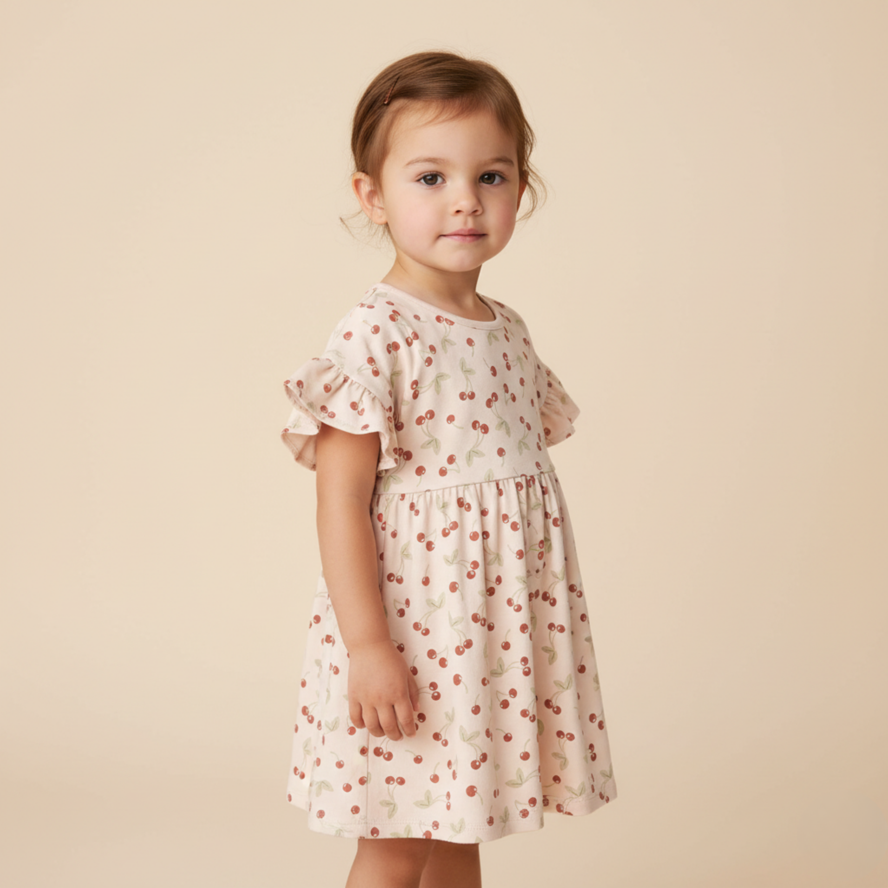 Young girl wearing a floral dress against a beige background
