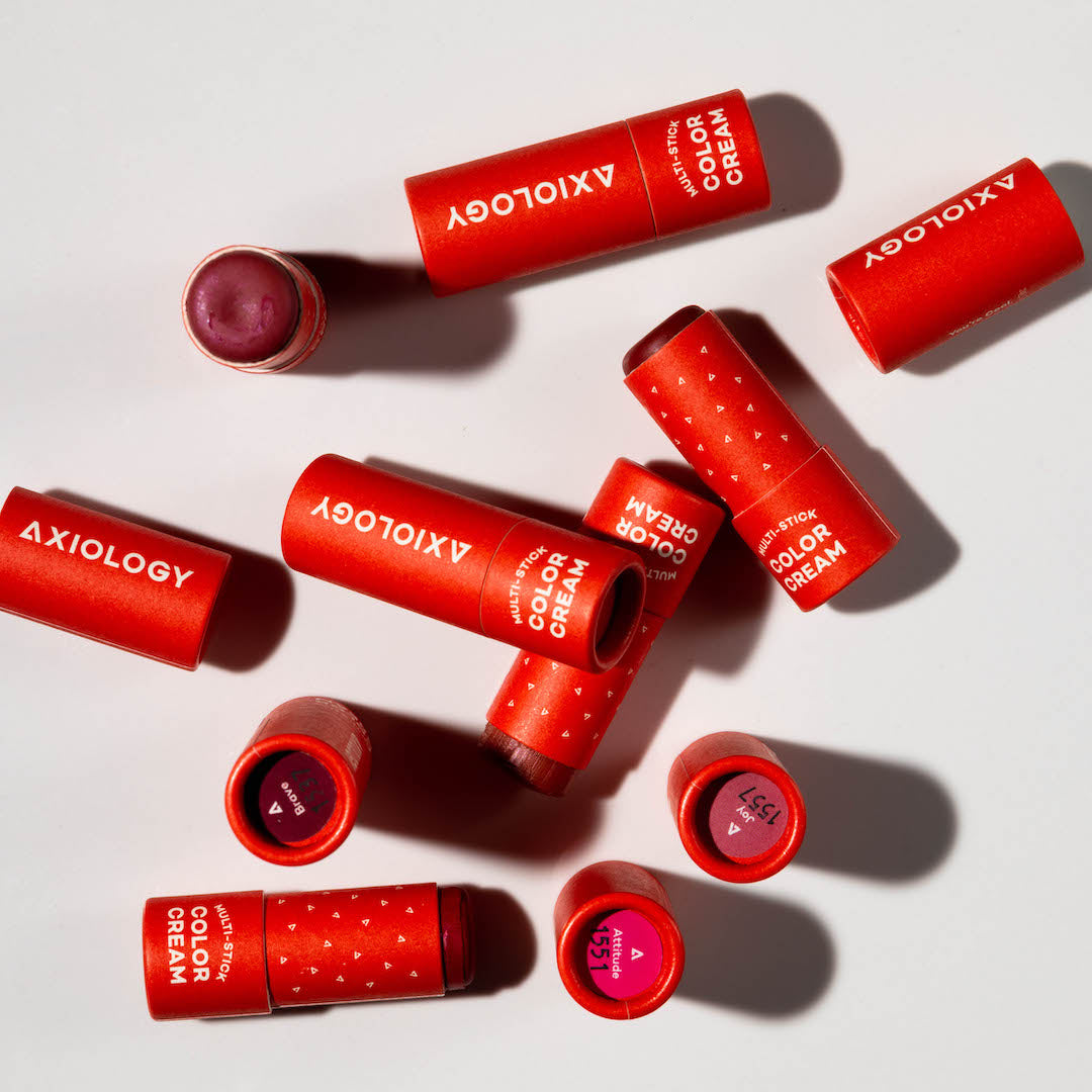 Red Axiology lipsticks on a light background
