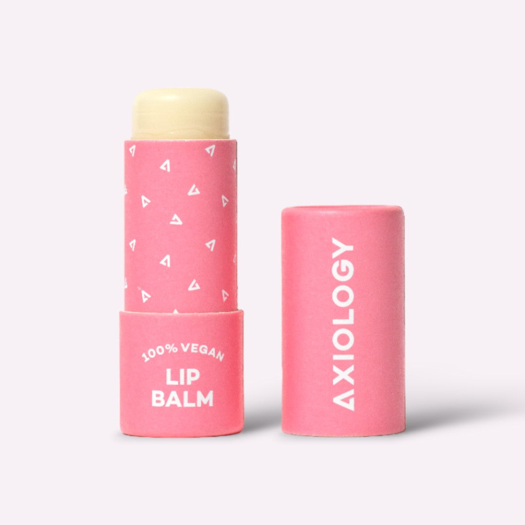 Pink lip balm with a white cap on a light gray background