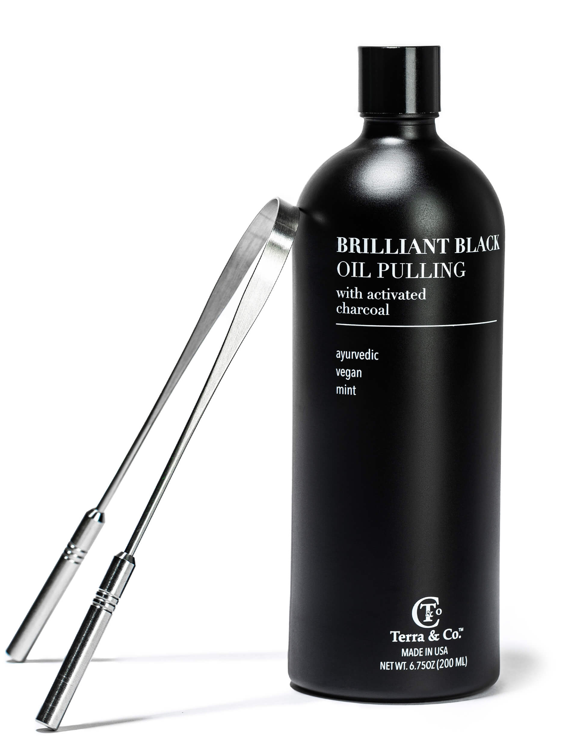 Black bottle of 'Brilliant Black Oil Pulling' with a tong on a white background