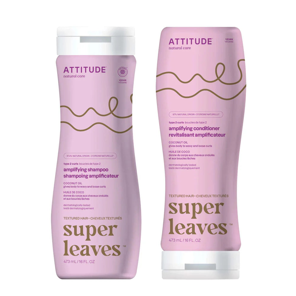 Two bottles of Attitude shampoo and conditioner with pink packaging on a white background