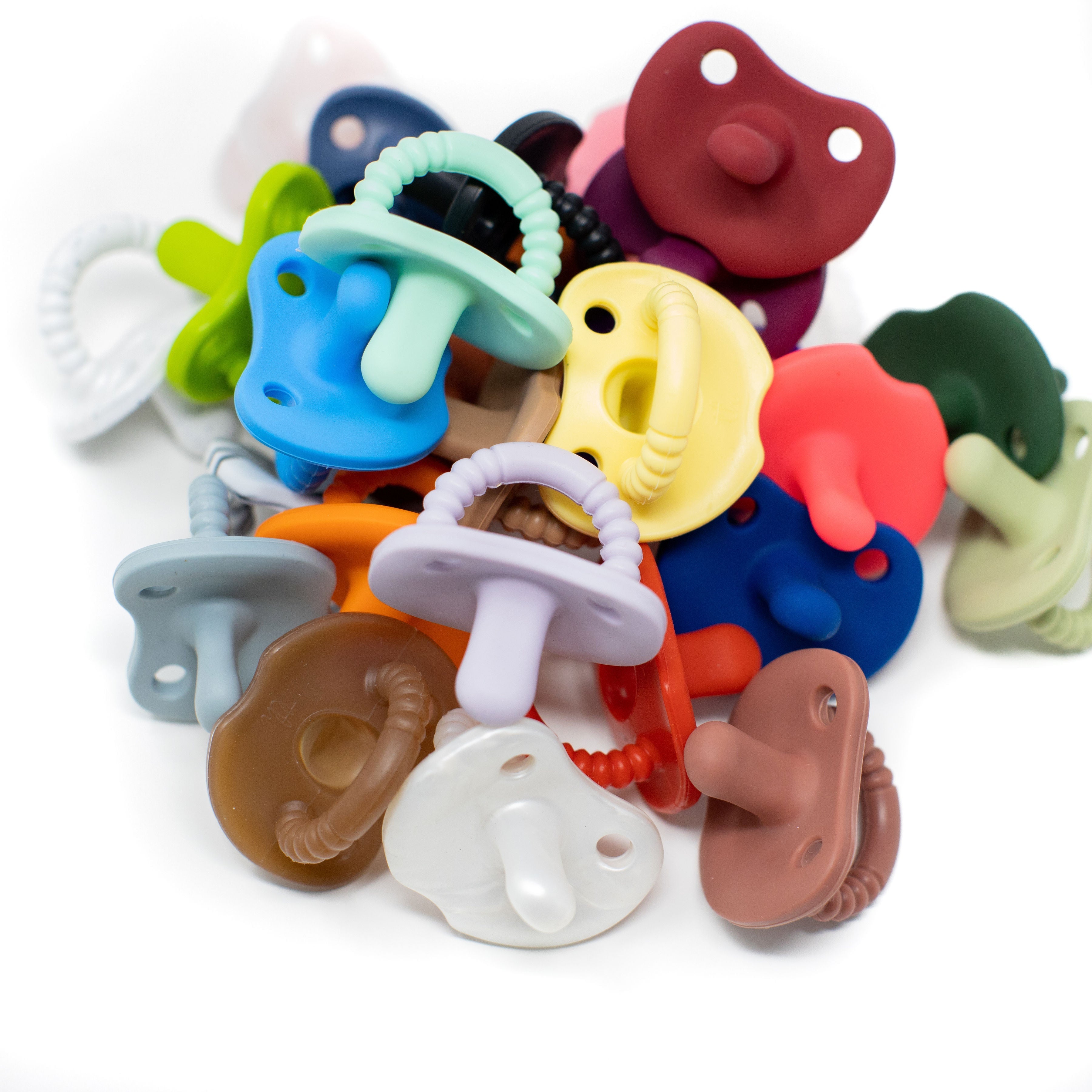 Assorted colorful baby pacifiers on a white background