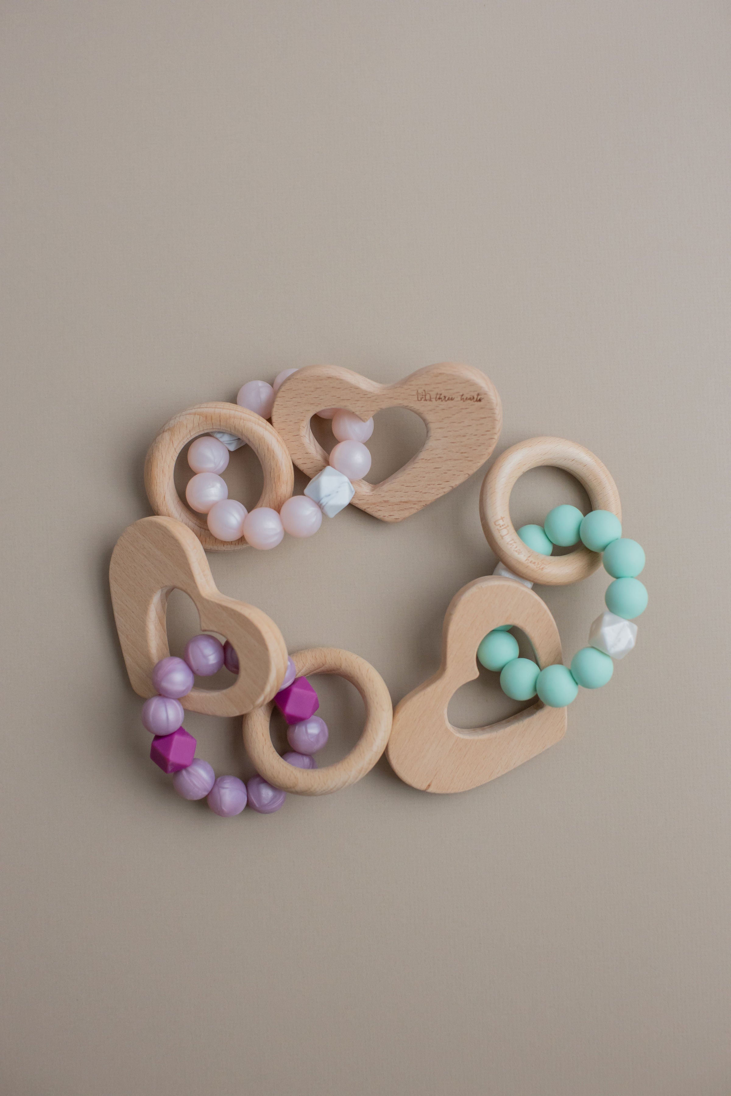Wooden teething ring with colorful beads on a beige background