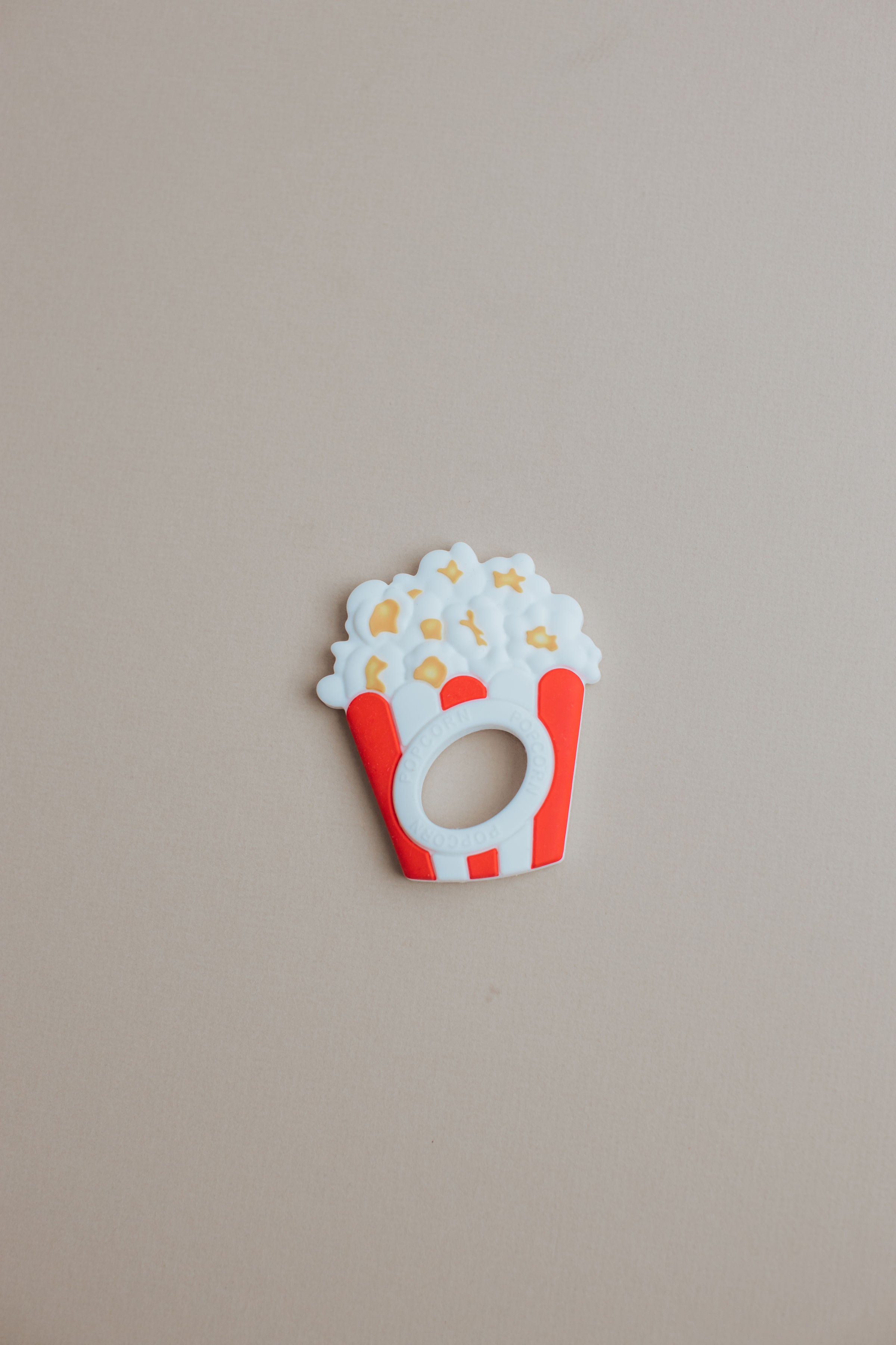 Decorative popcorn bucket with popcorn on a beige background