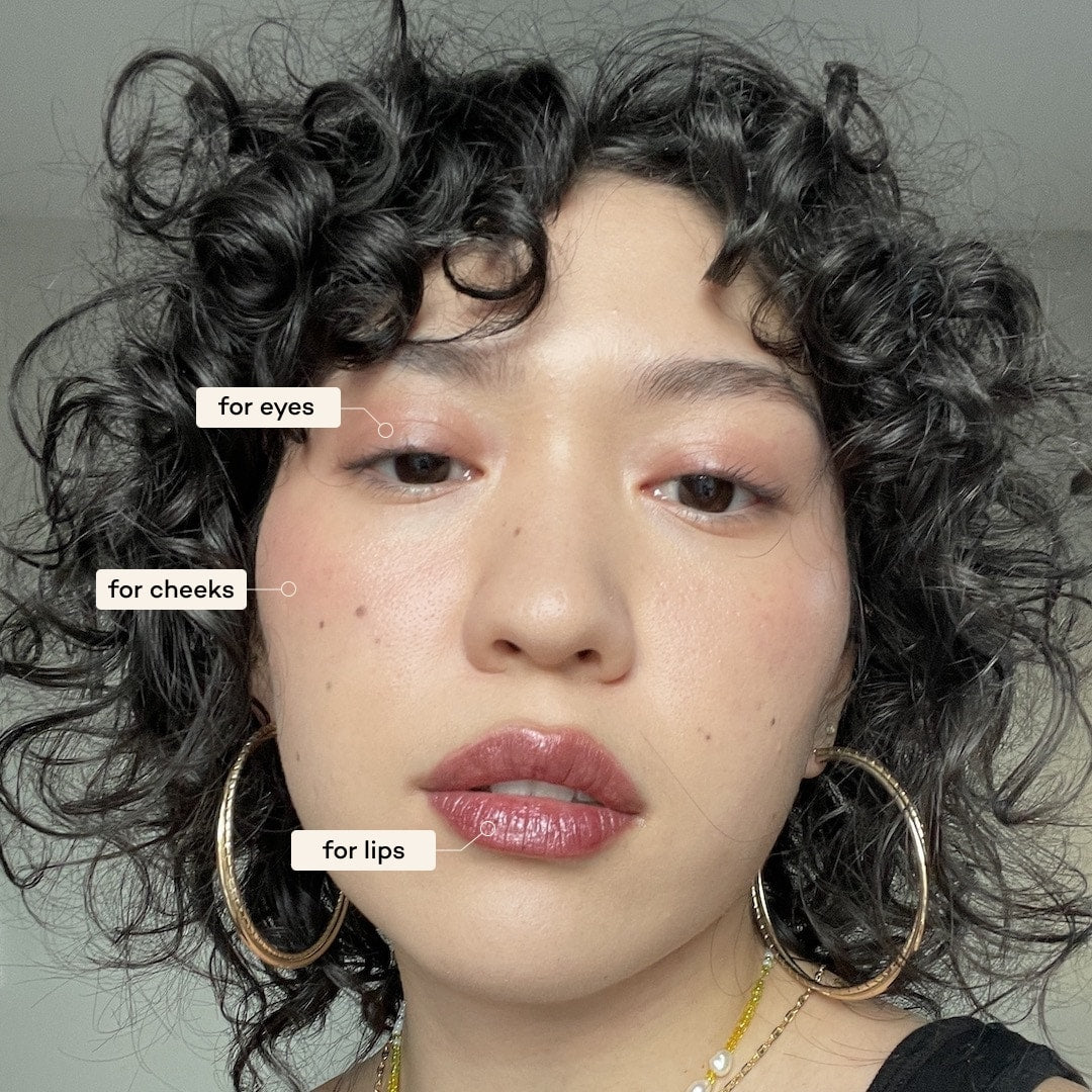 Close-up of a person with text labels for makeup application on eyes, cheeks, and lips.