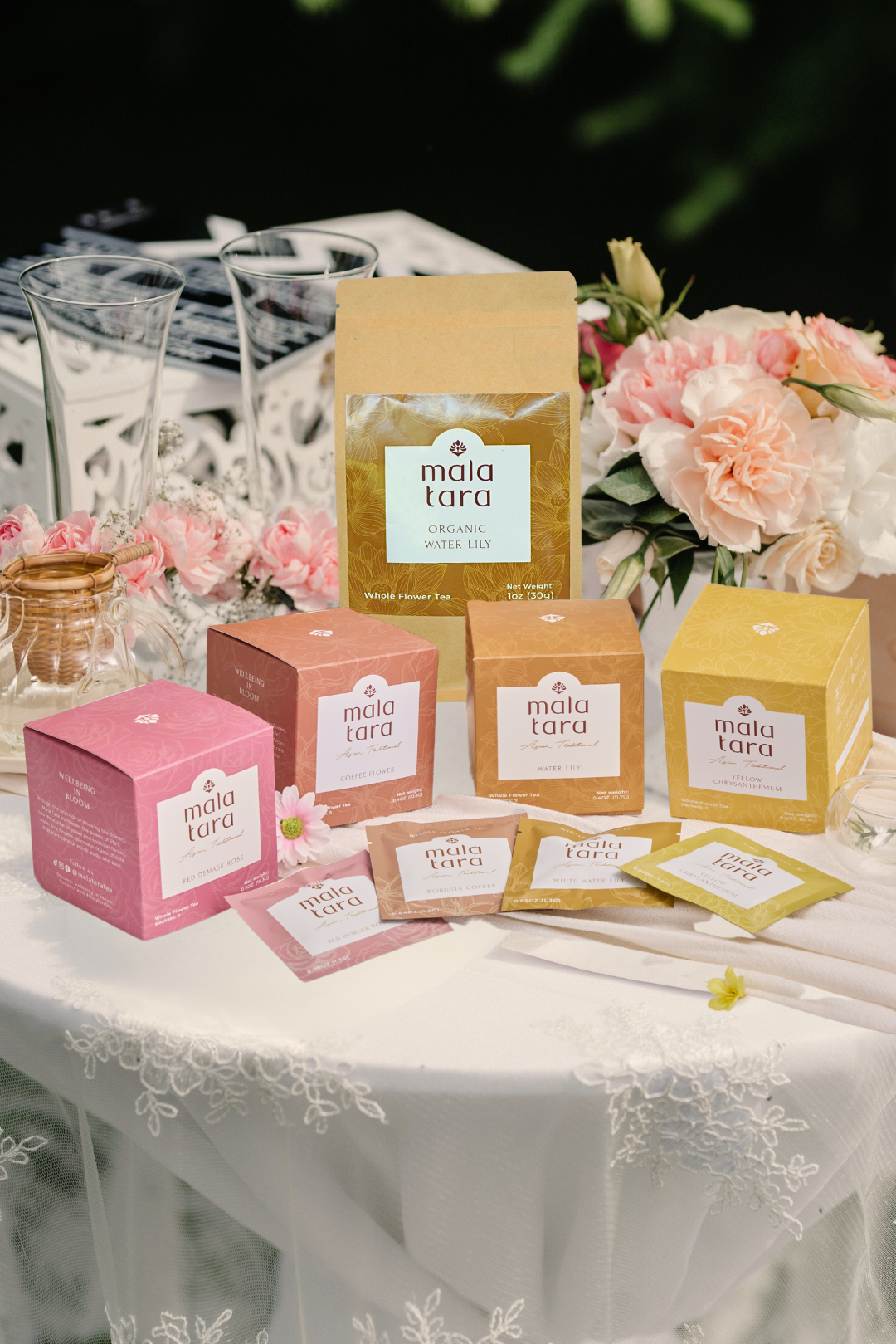 Mala Tara products on a table with flowers and decorative items.