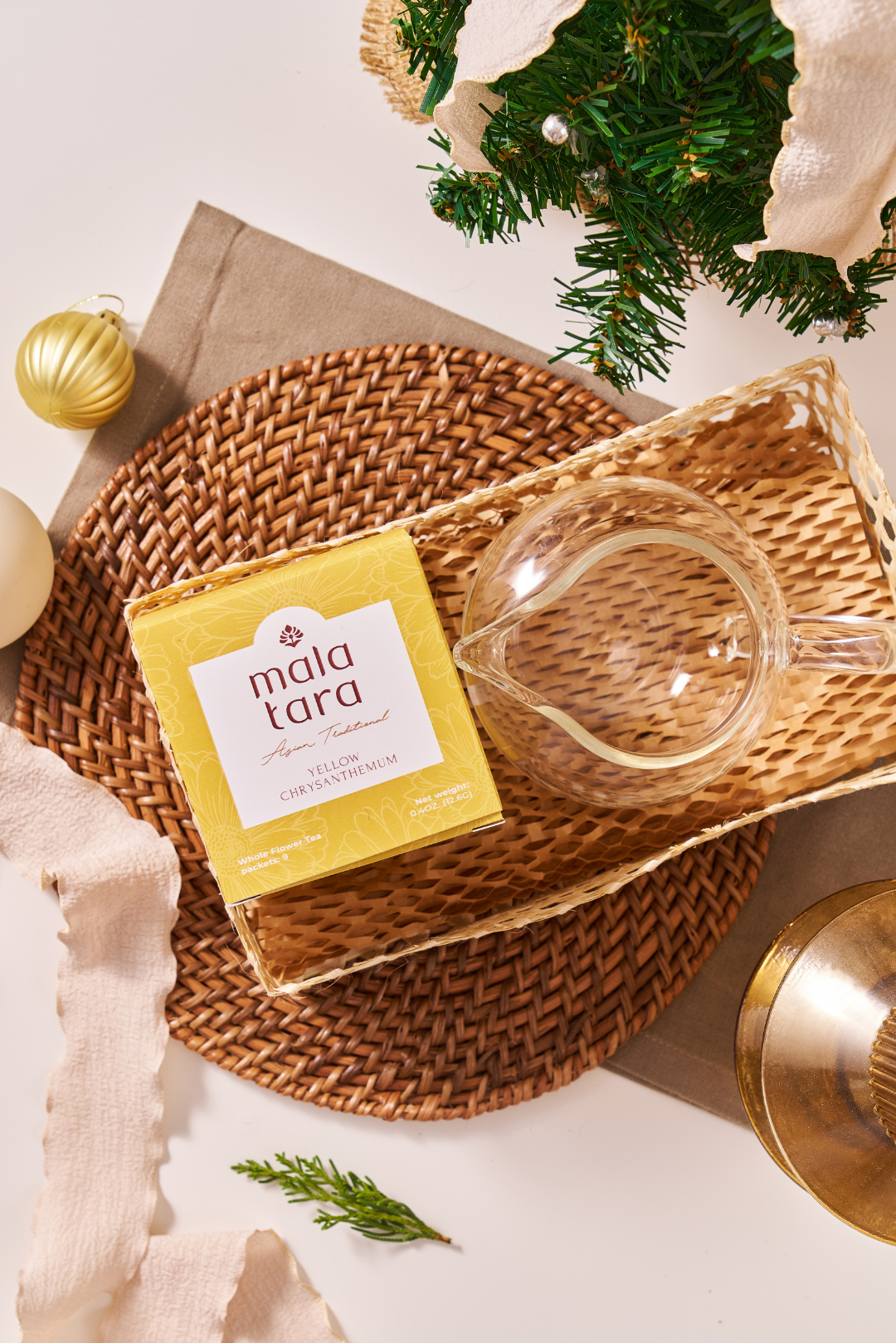 Yellow box labeled 'mala tara' on a woven tray with decorative items.