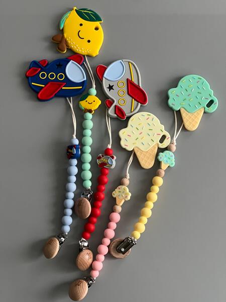 Colorful baby teething toys with various shapes and designs on a gray background