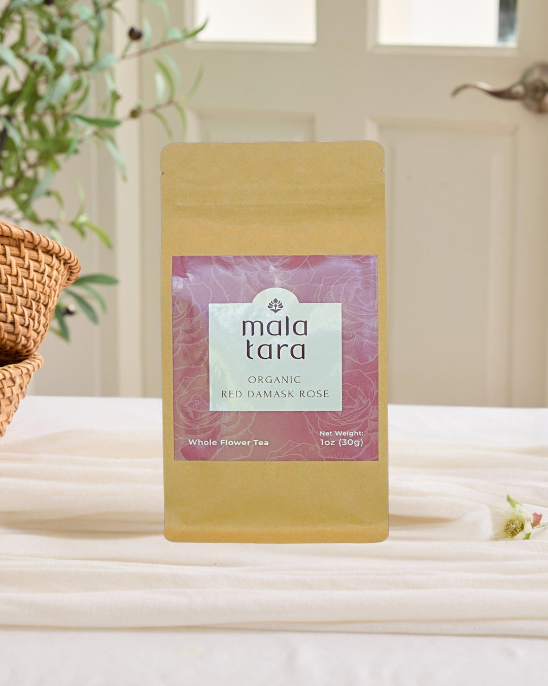 Mala Tara organic red damask rose tea package on a white surface with a blurred background