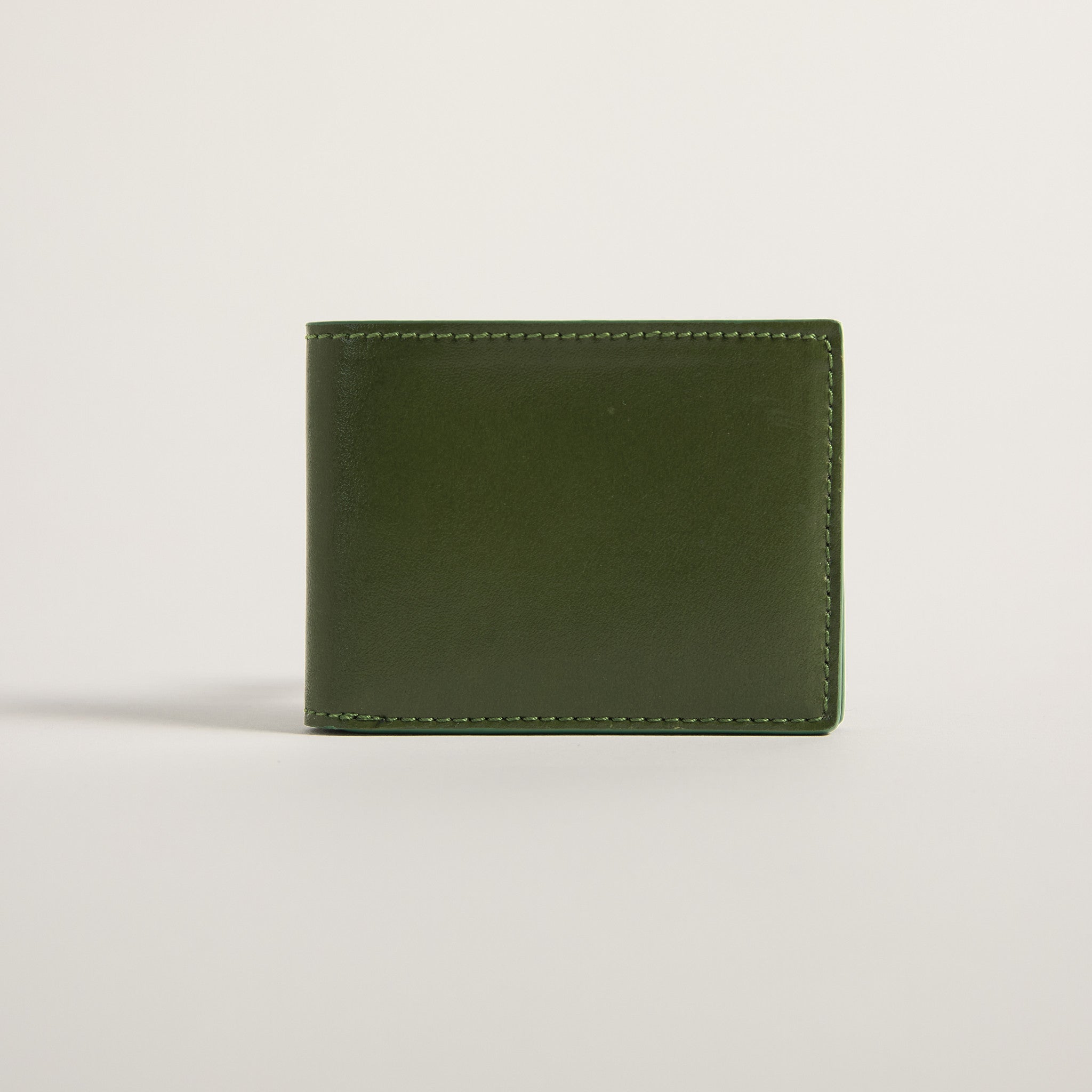 An olive green leather bifold wallet with matching green stitching, shown closed on a clean, light gray studio background.