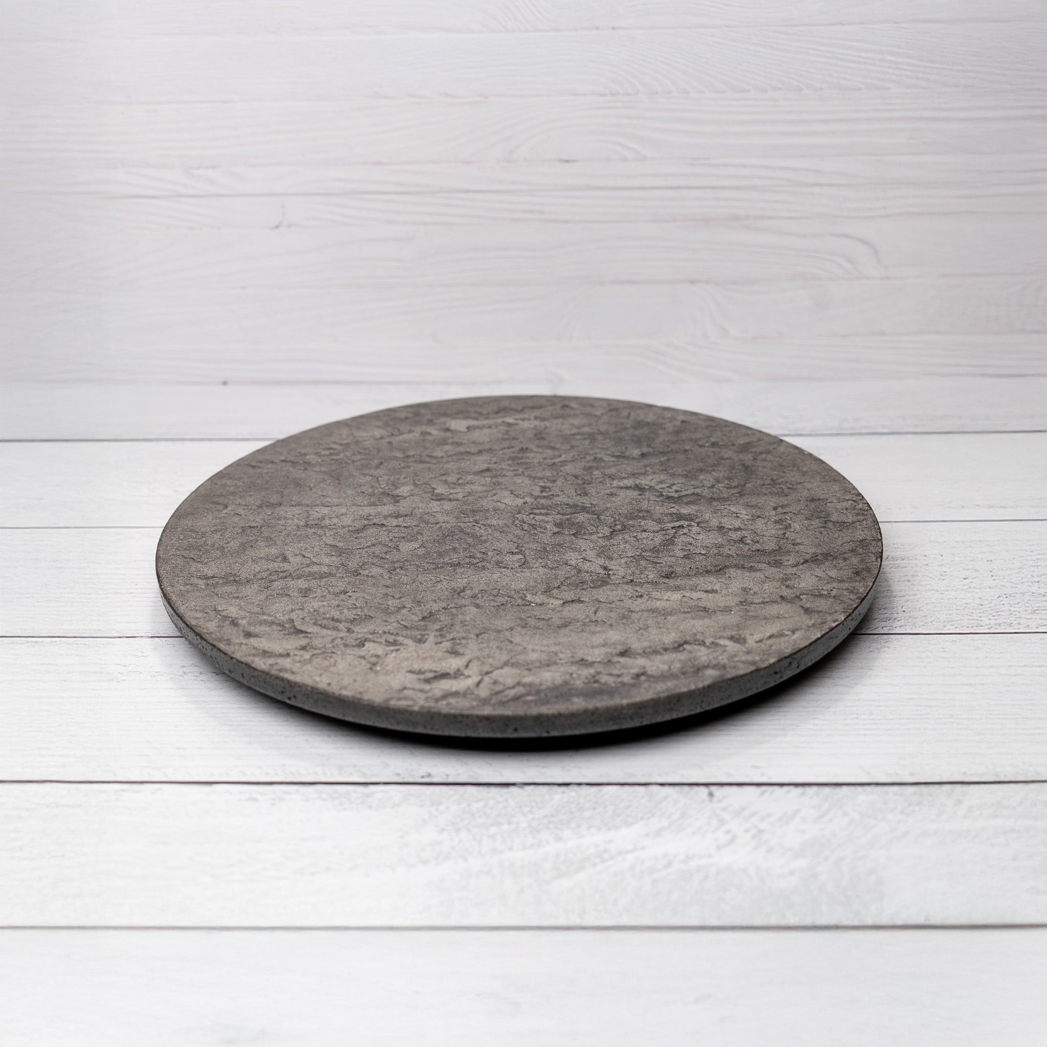 Round stone coaster on a white wooden surface