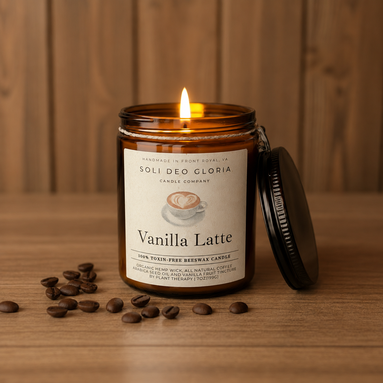 A lit amber glass candle jar labeled 'Vanilla Latte' by Soli Deo Gloria Candle Company, with the black lid leaning against it on a wooden surface and scattered coffee beans in front.