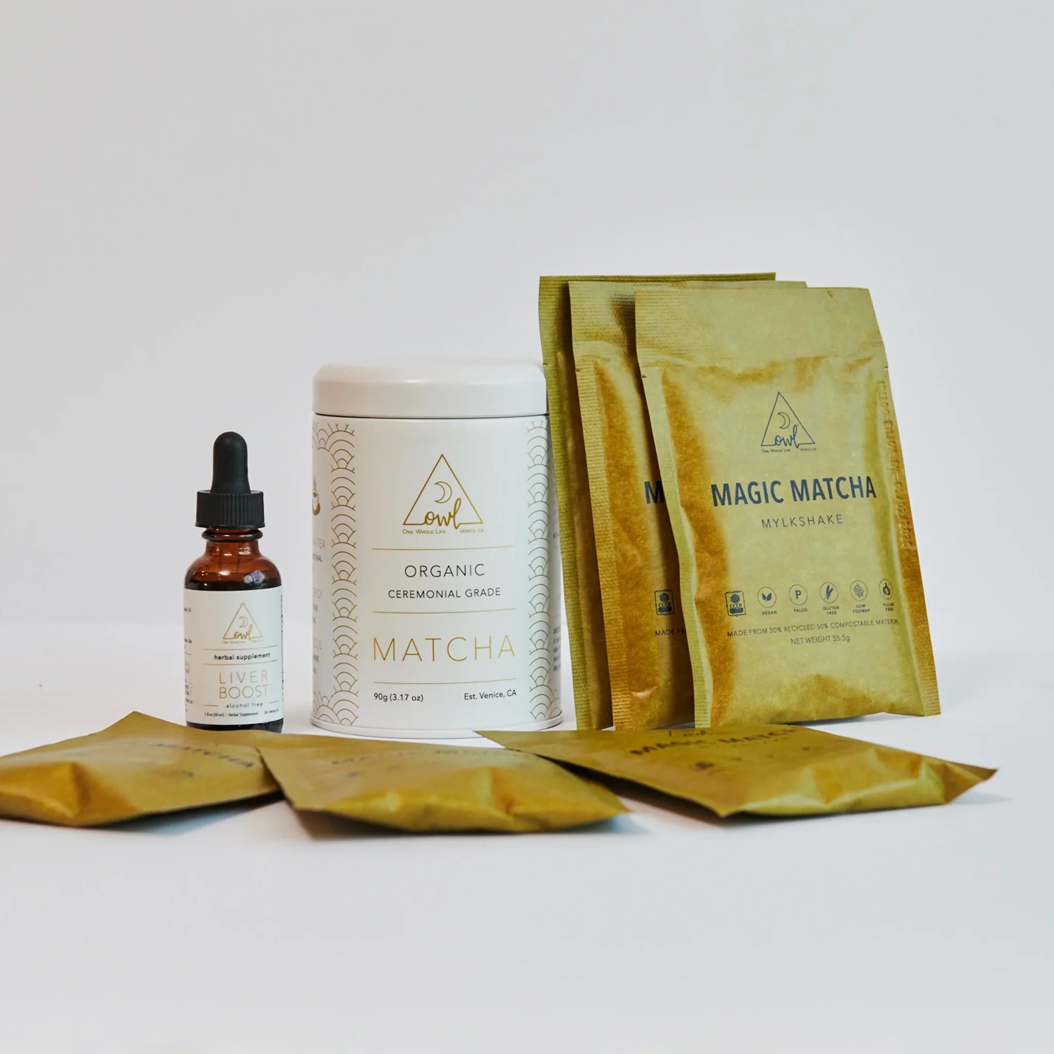 Matcha products including a bottle, container, and packets on a white background