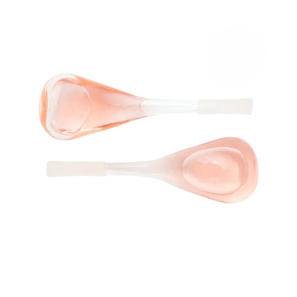 Two pink silicone spoons on a white background