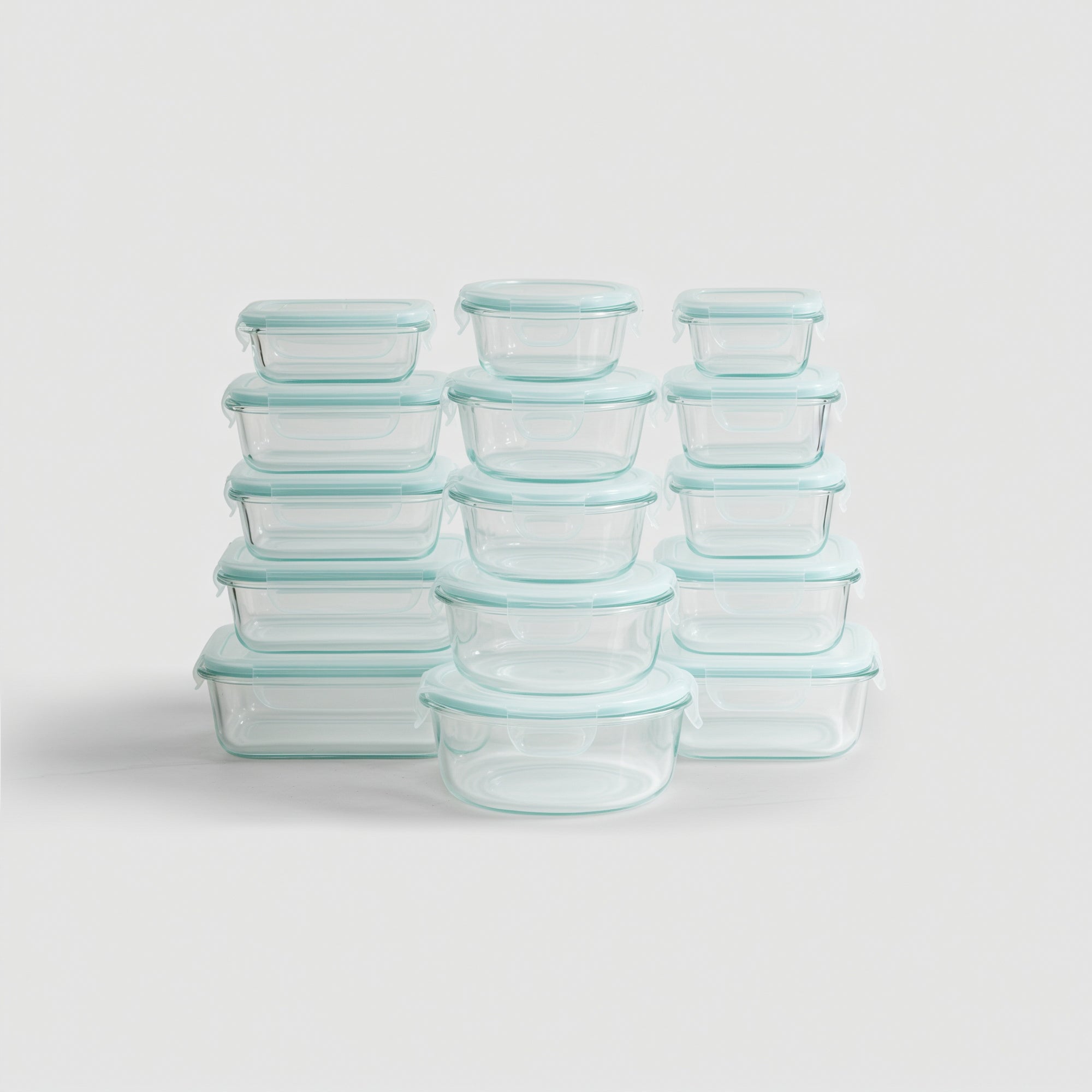 Set of glass food storage containers with blue lids on a light gray background