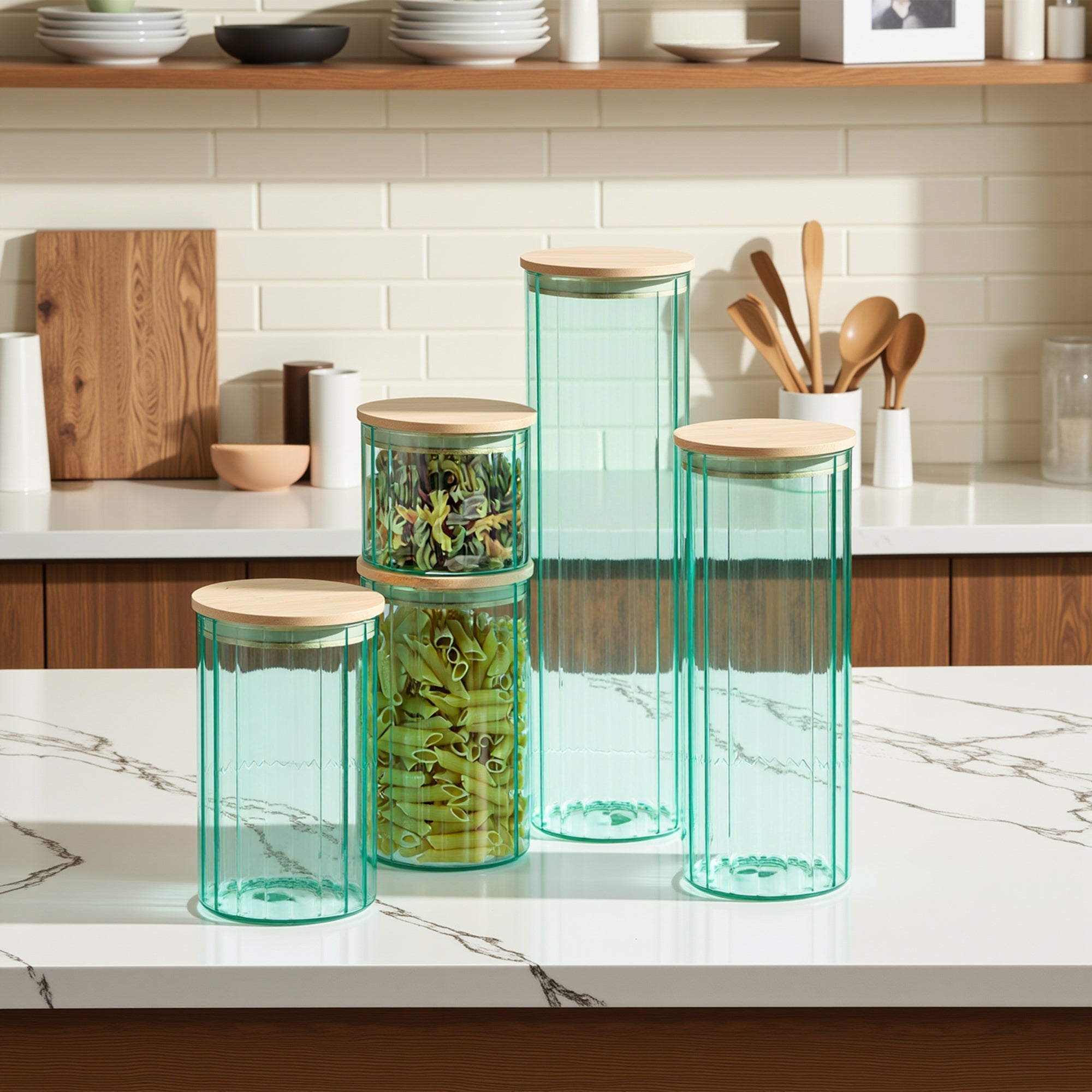 Set of teal glass canisters with wooden lids on a kitchen counter.