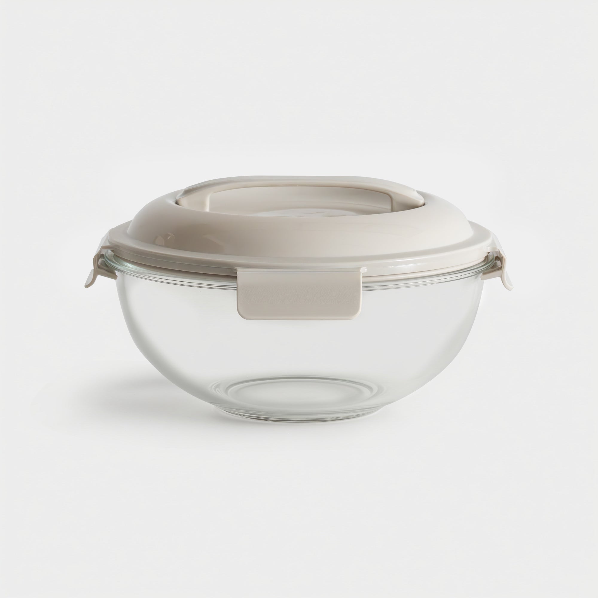 Clear glass container with a beige lid on a white background